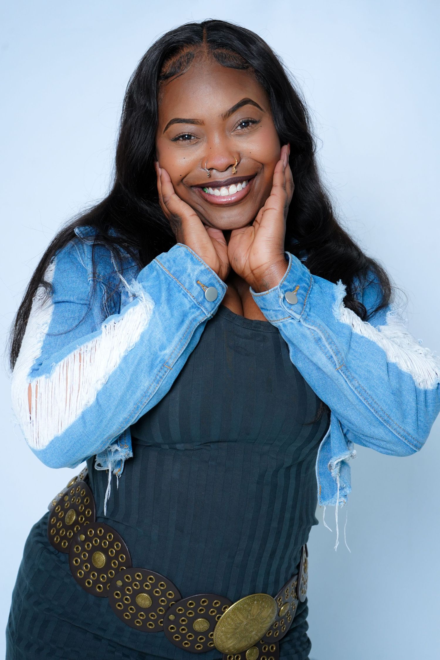Studio portraits showing playful expressions while wearing denim jacket and decorative belt.