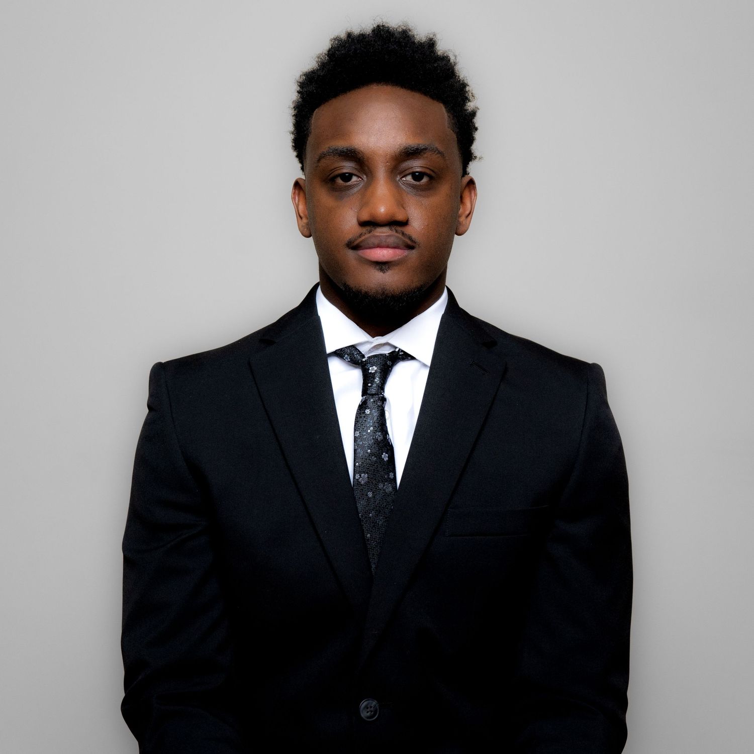 Professional portrait of person in business attire with vest and tie smiling warmly.