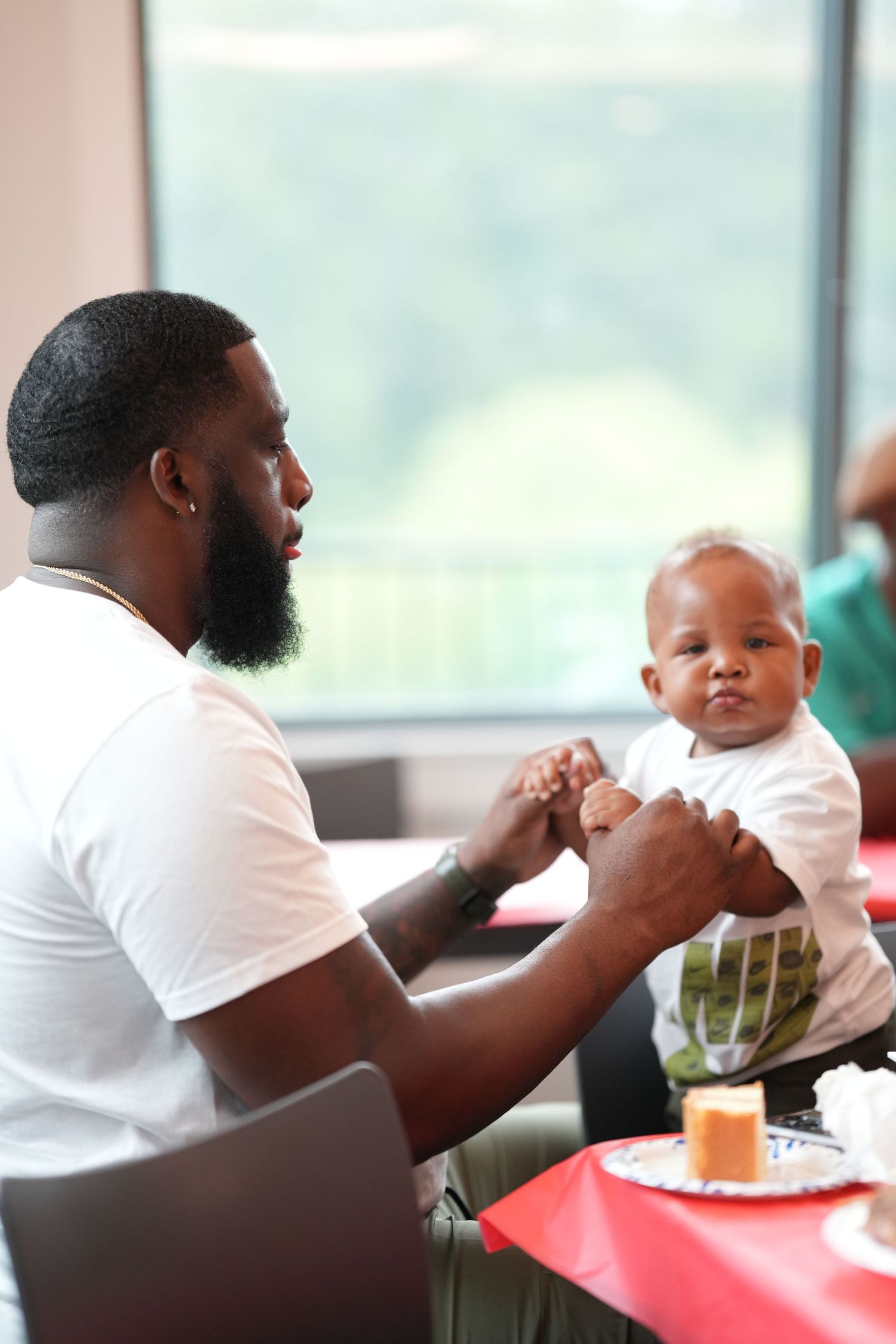 A parent and baby share a tender moment during mealtime at a restaurant.