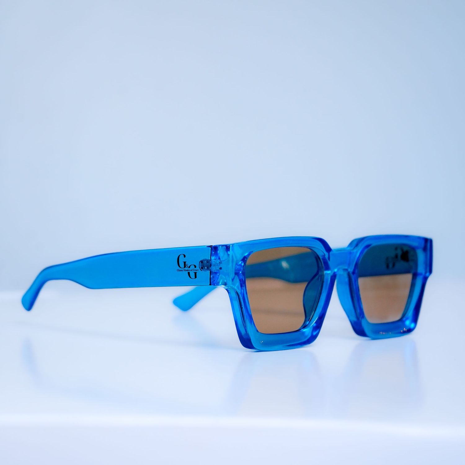 Blue rectangular sunglasses shown from different angles on white background.