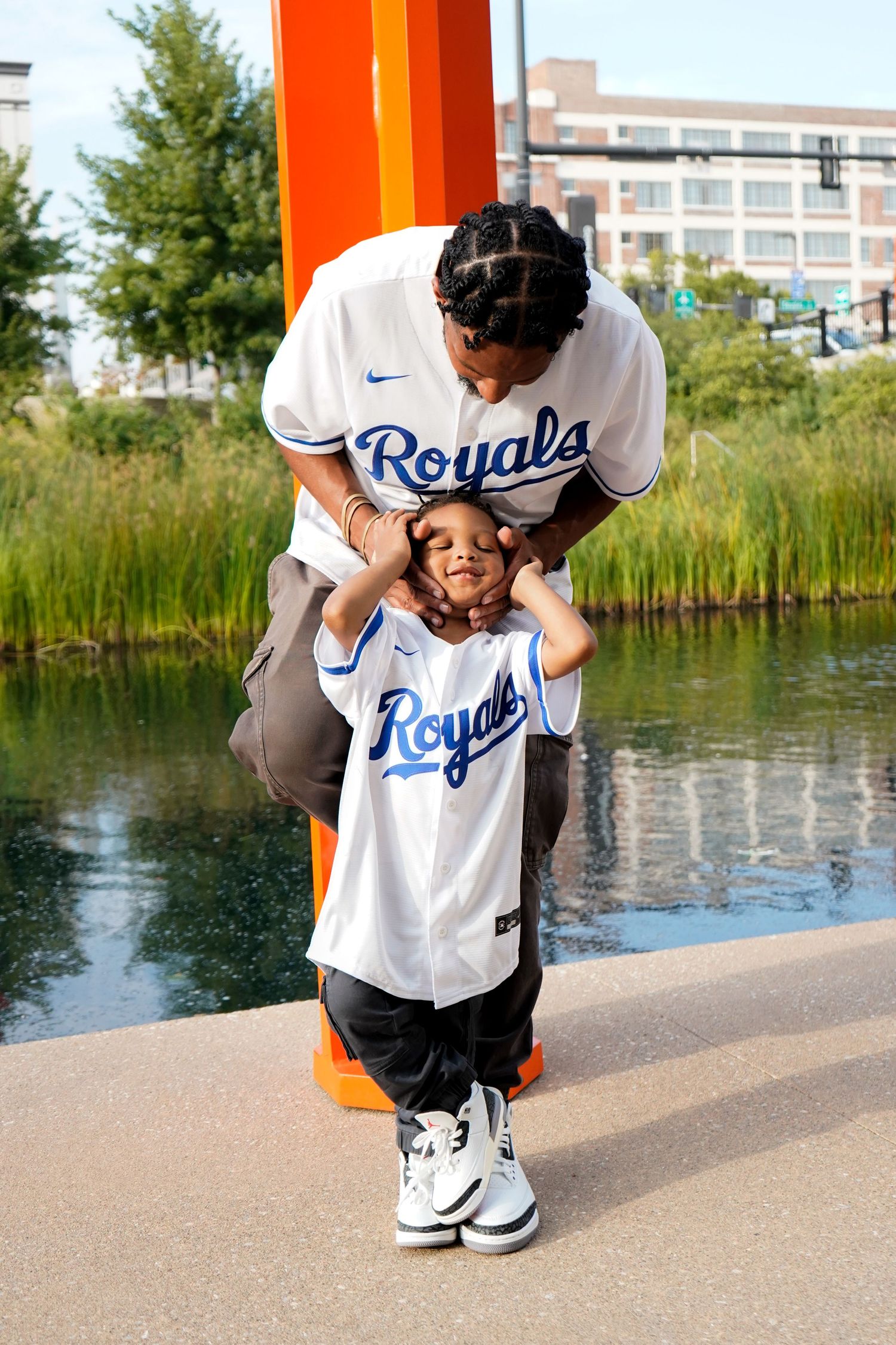 Kansas City Royals baseball jersey shown in a sequence of photos near a waterfront with reeds and buildings in background.