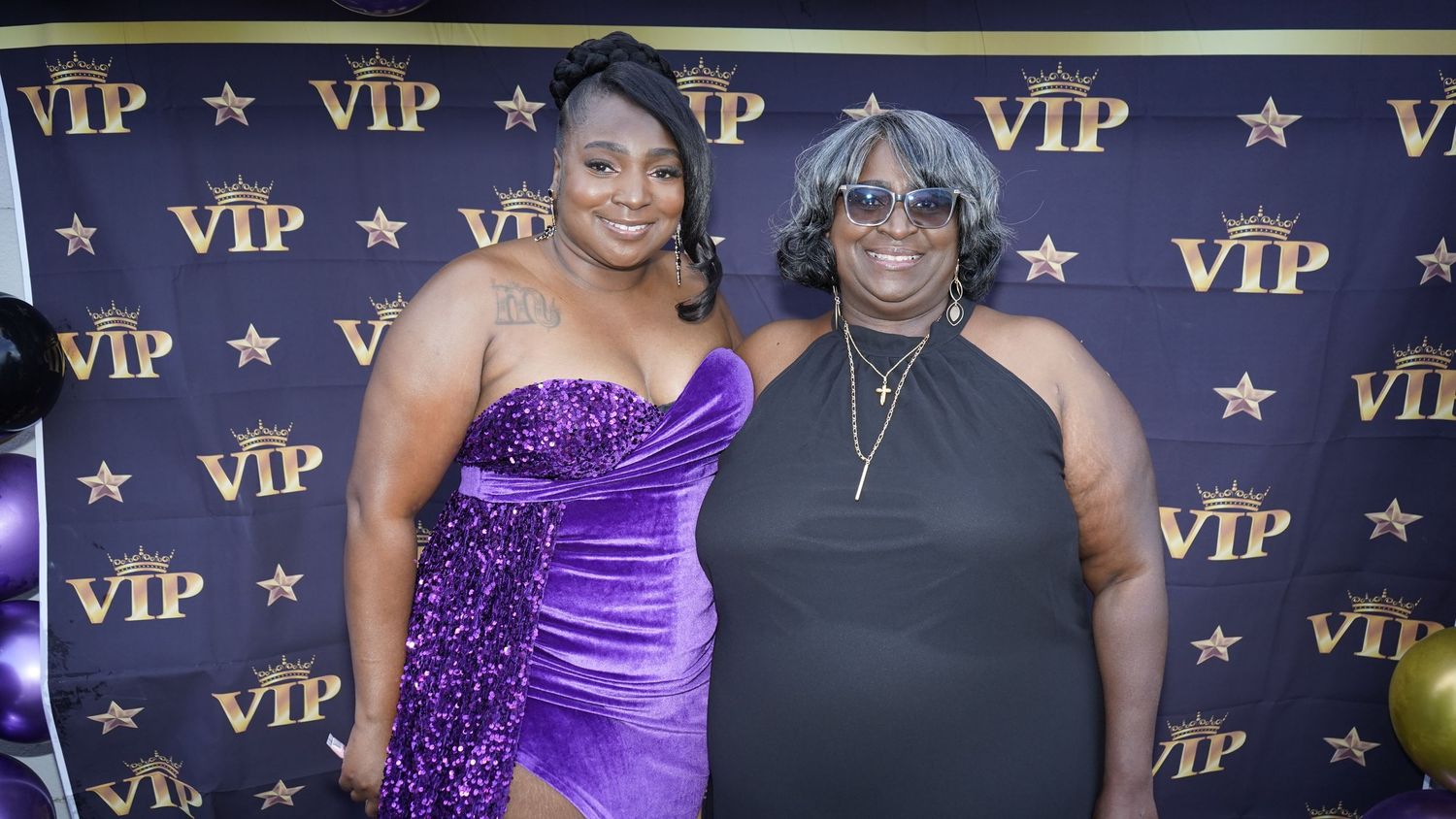 Group photo of attendees in formal attire against a VIP backdrop with gold stars.