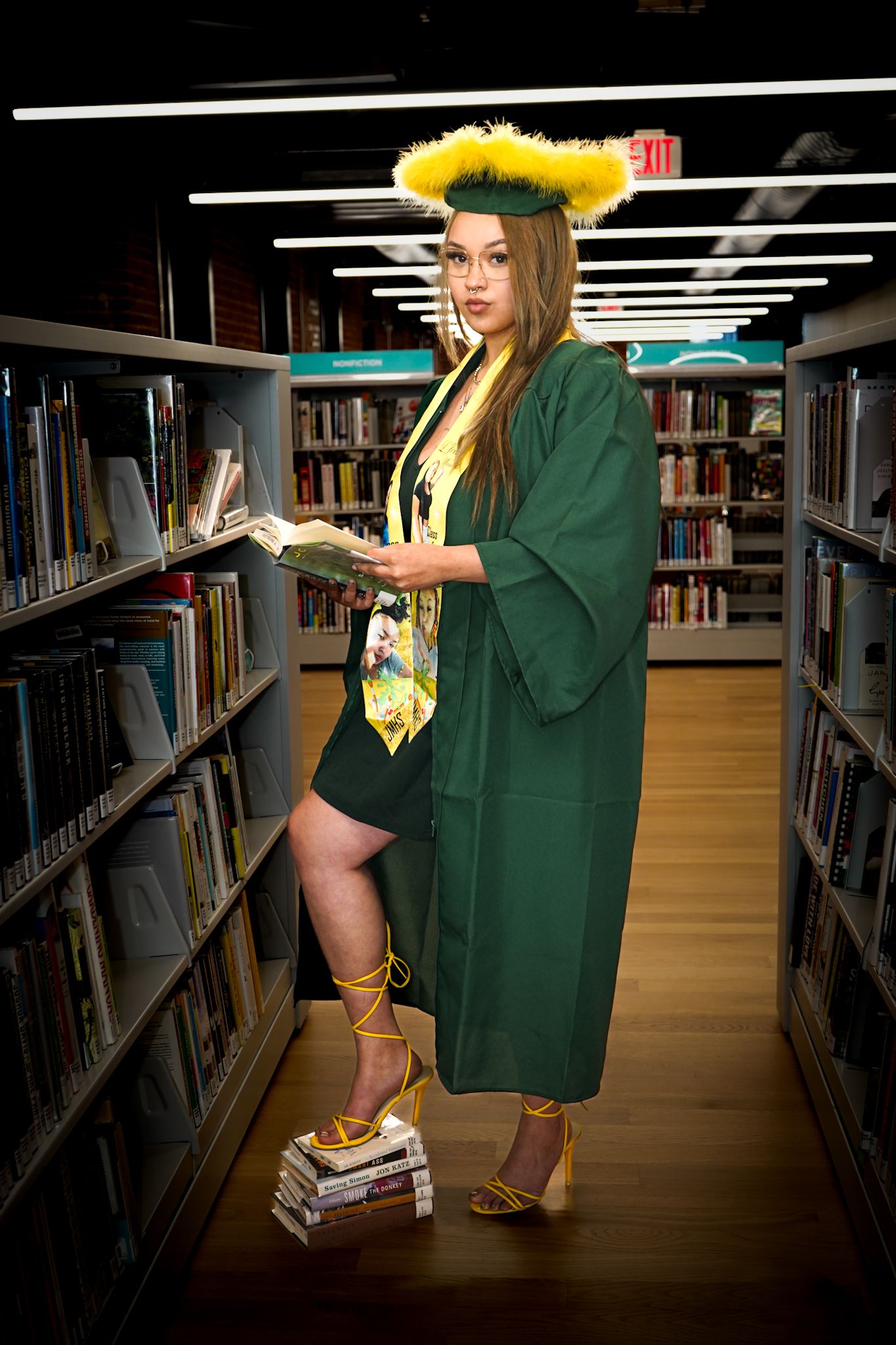 Graduation photos in a library featuring green academic regalia and sunflowers.