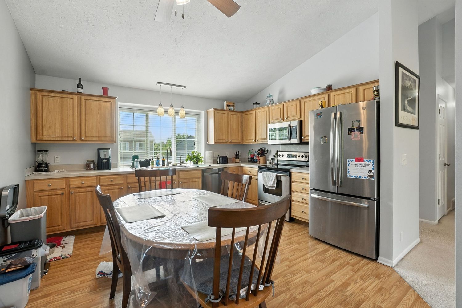 Open concept kitchen and dining area with wooden cabinets and modern appliances.