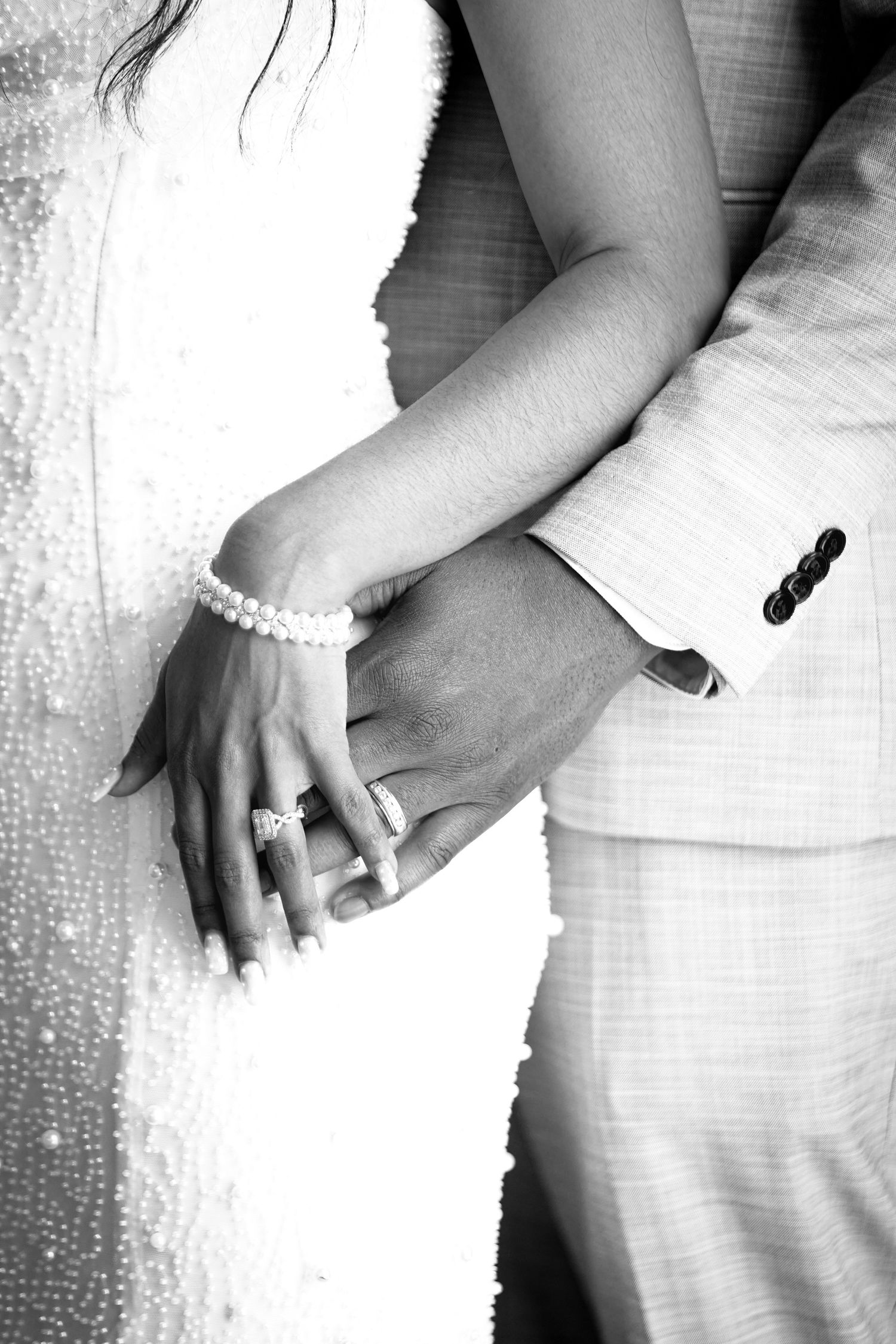 Black and white detail shots of hands with wedding rings in elegant formal attire.