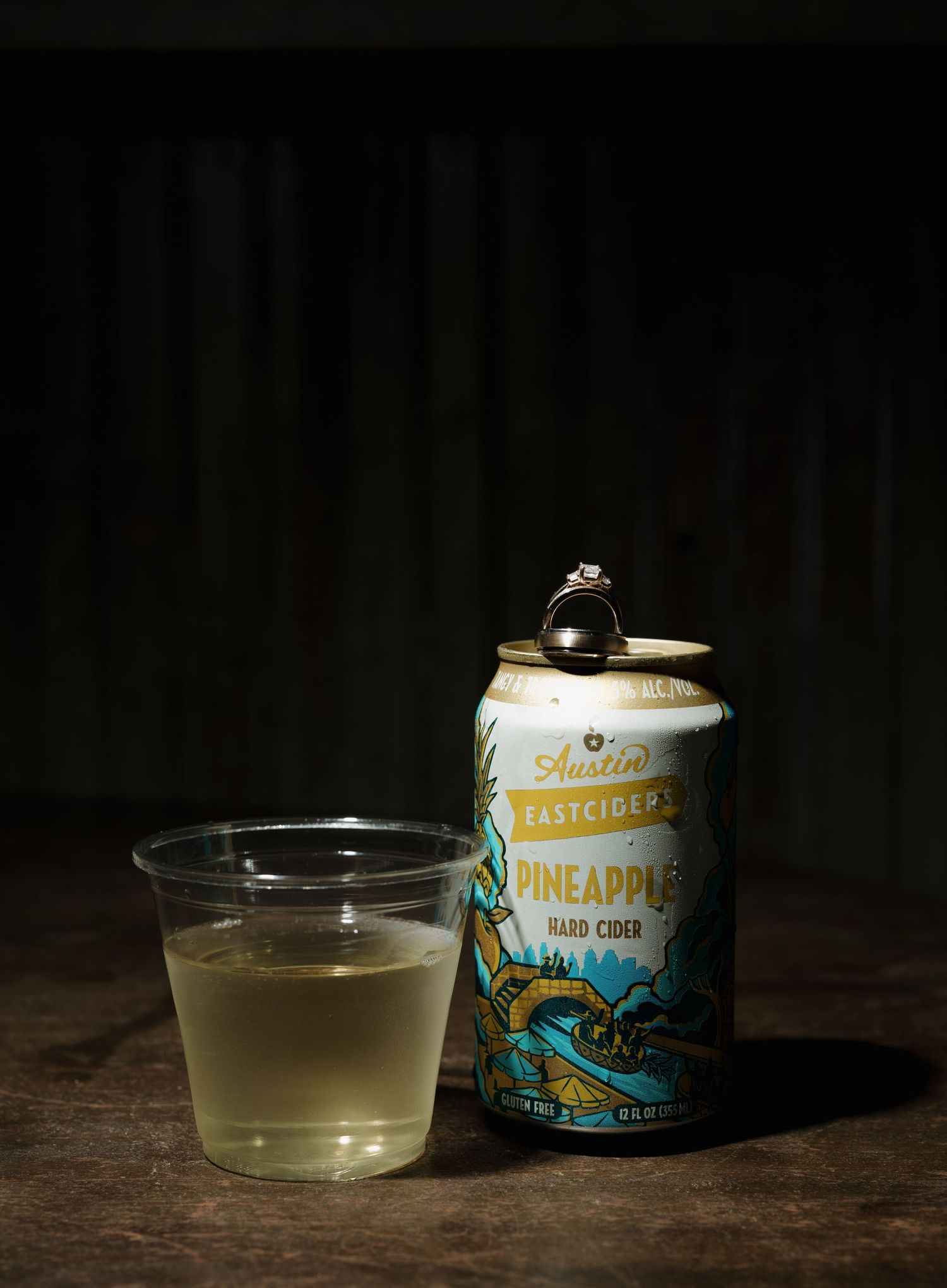 A series of four moody photographs showing a glass bowl with clear liquid and a tropical-themed beverage can in dark lighting.