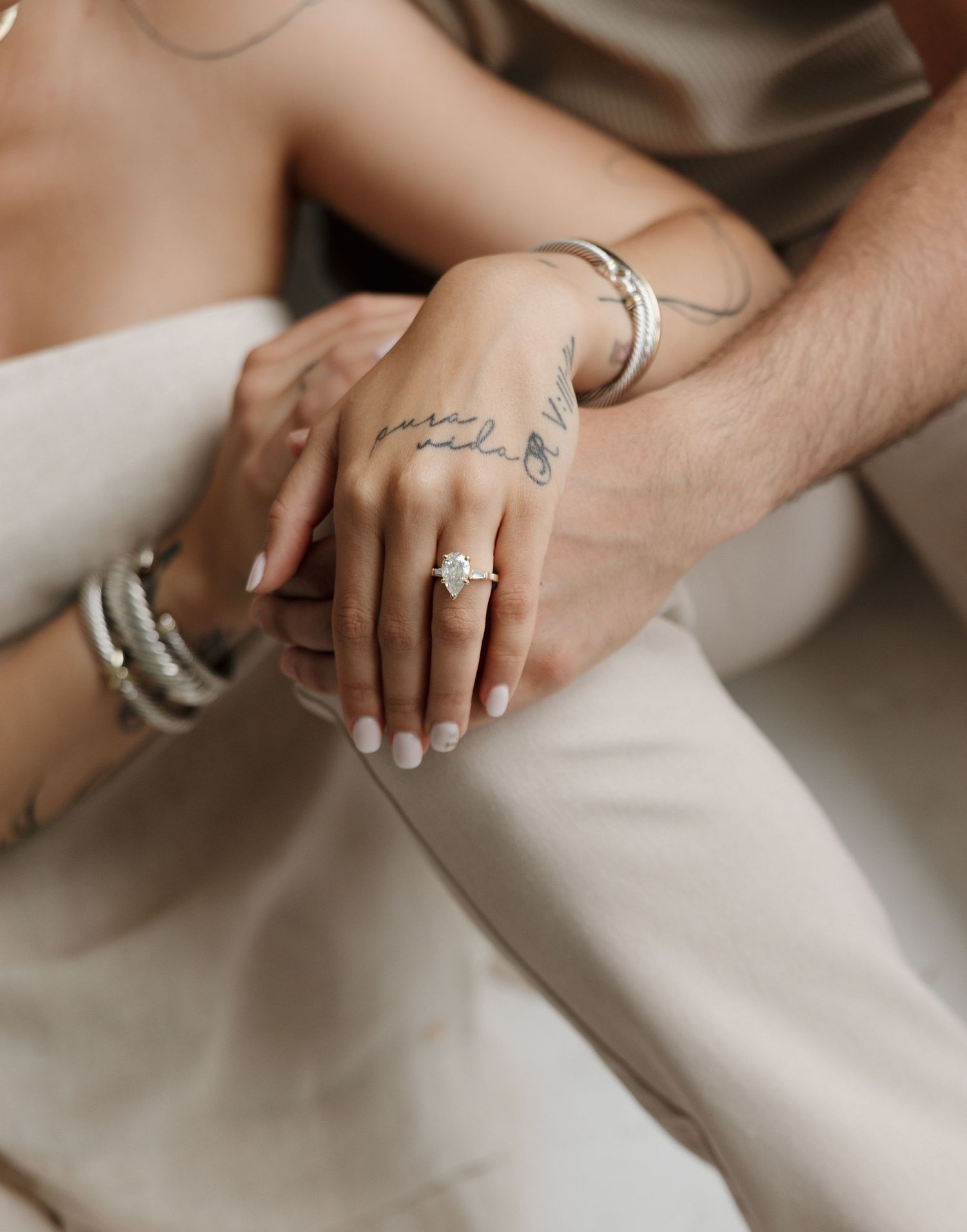 Close-up of hands with engagement rings showing various angles of diamond solitaire and wedding band details.
