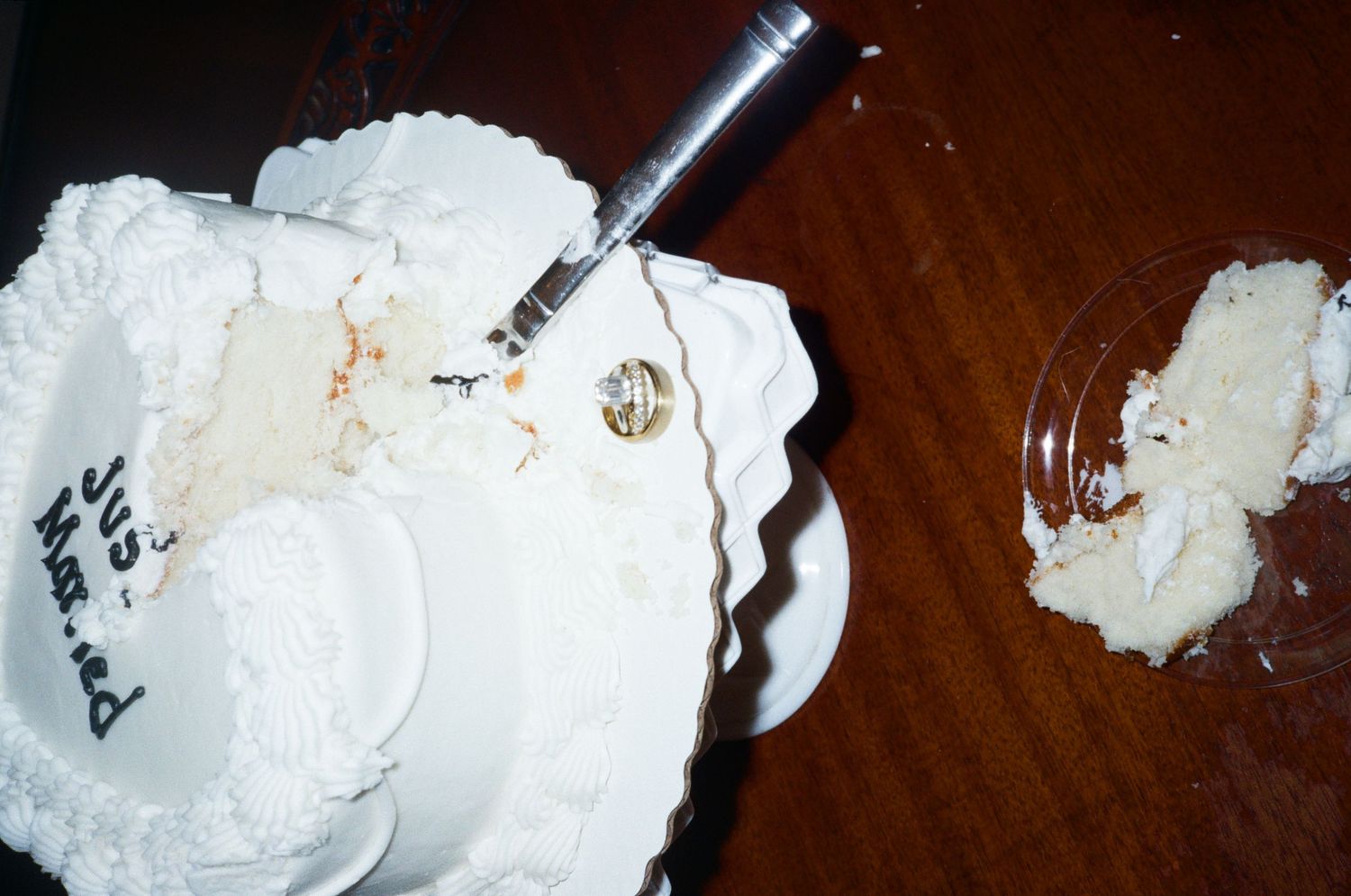Empty plates with cake crumbs and silverware on dark wooden table.