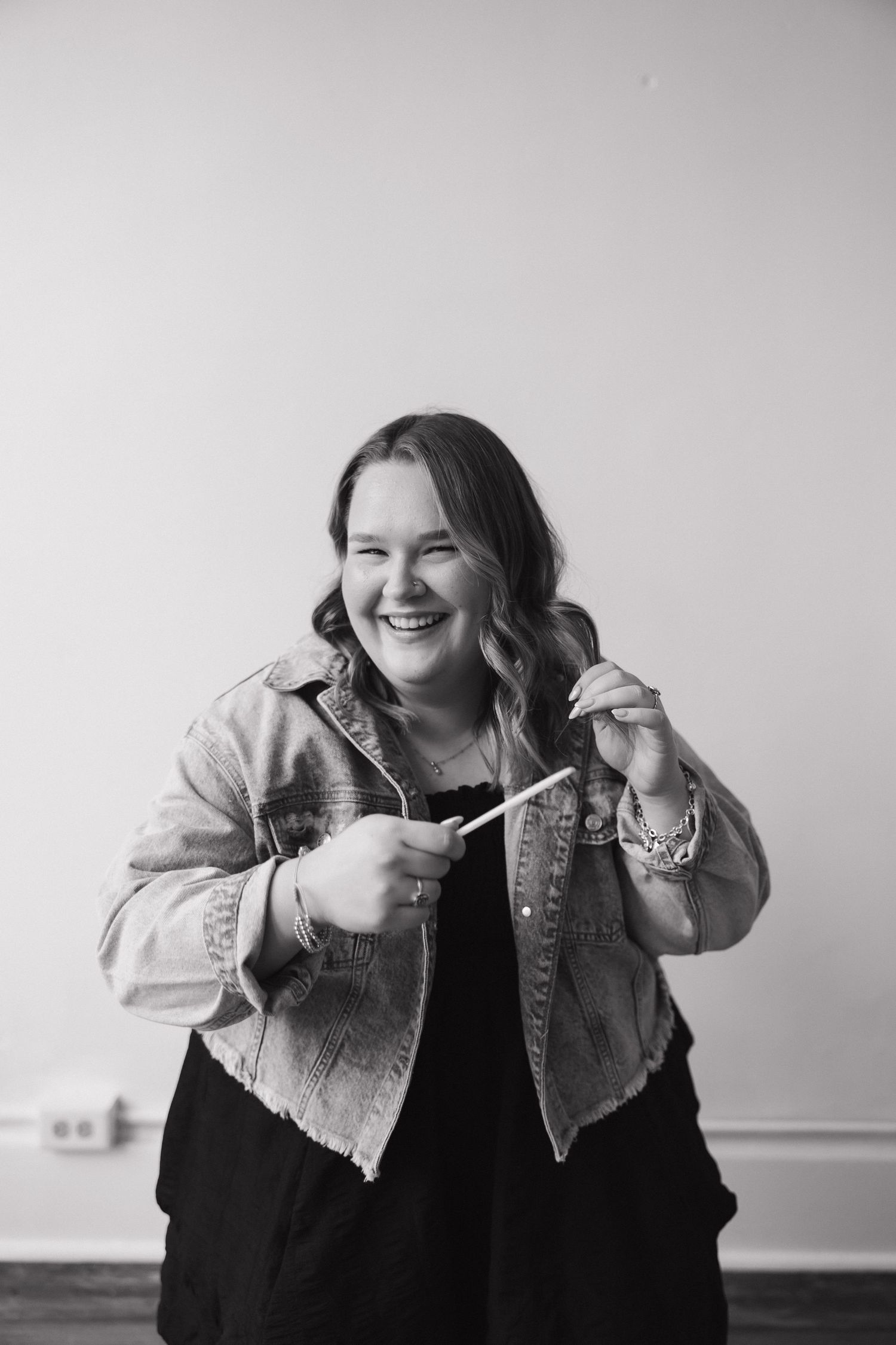 Black and white portrait against plain background showing joyful expression.