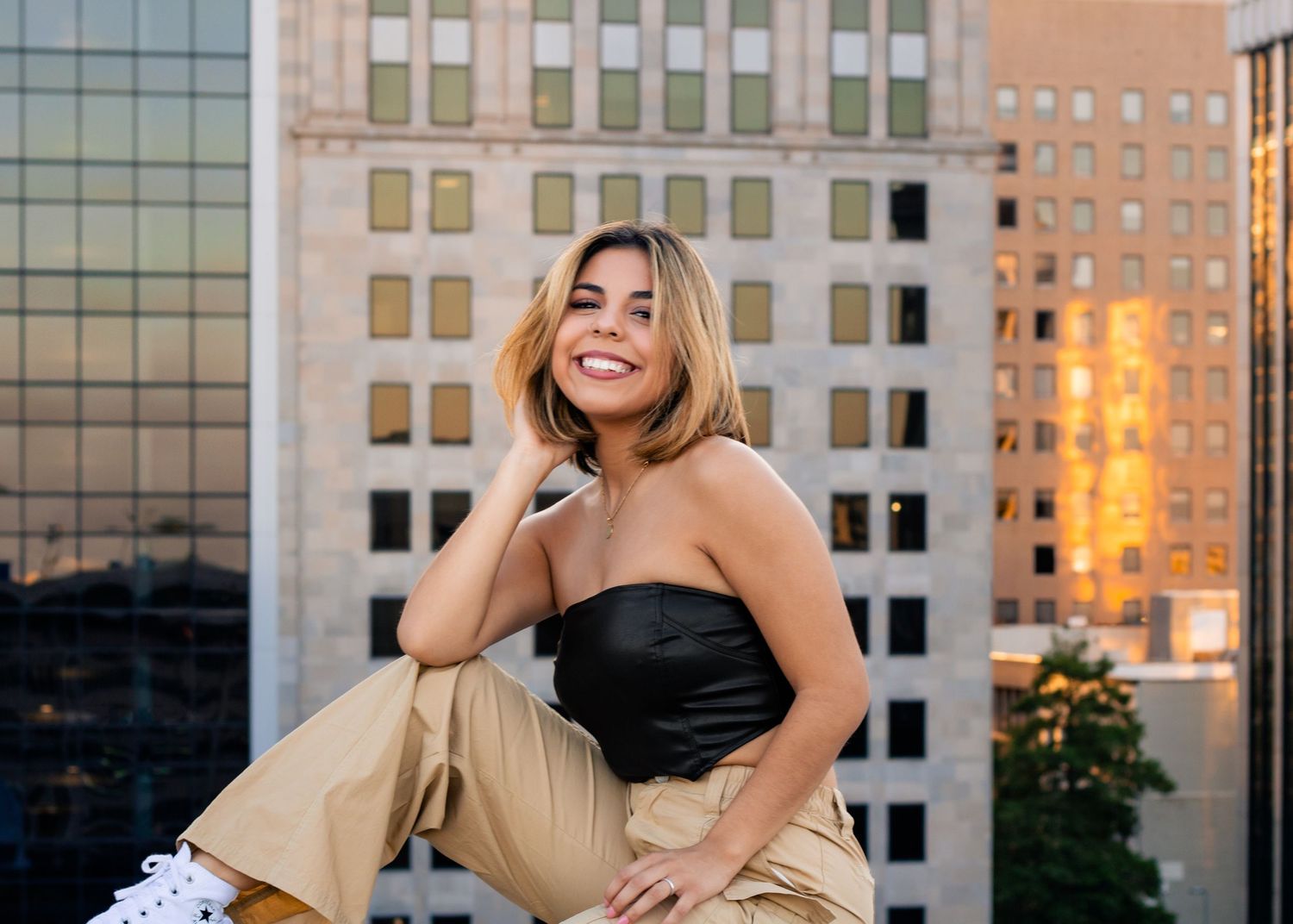 OKC senior on rooftop parking garage with skyline at sunset, photographed by Edmond & OKC photographer Taylor Maze, natural light portraits.