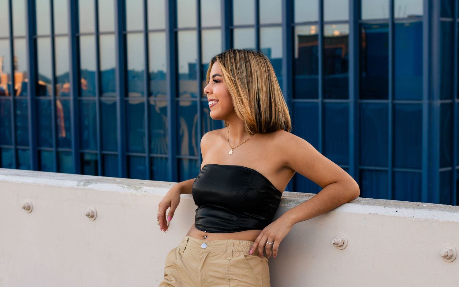 OKC senior on rooftop parking garage with skyline at sunset, photographed by Edmond & OKC photographer Taylor Maze, natural light portraits.