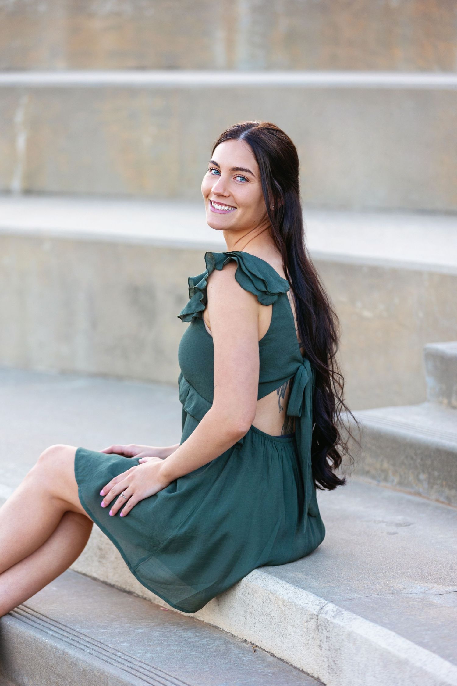Portrait of Oklahoma photographer Taylor Maze at UCO in a green dress, sitting, natural light, true-to-color lifestyle photography.