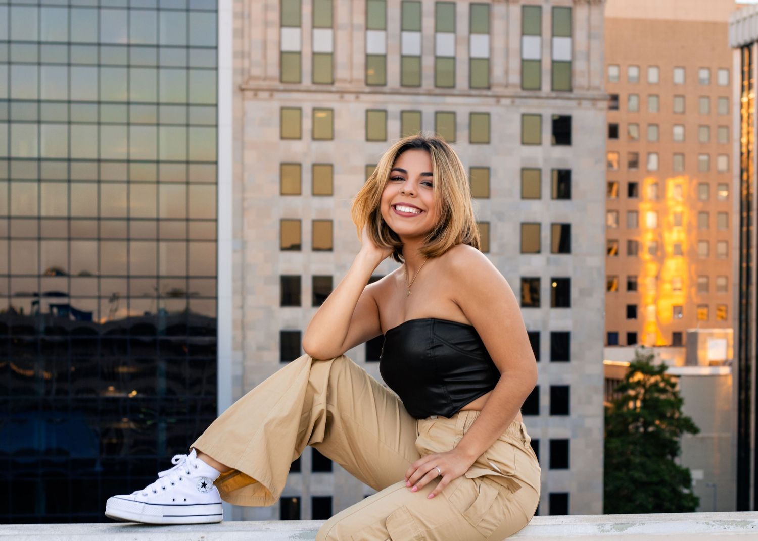 OKC senior on rooftop parking garage with skyline at sunset, photographed by Edmond & OKC photographer Taylor Maze, natural light portraits.