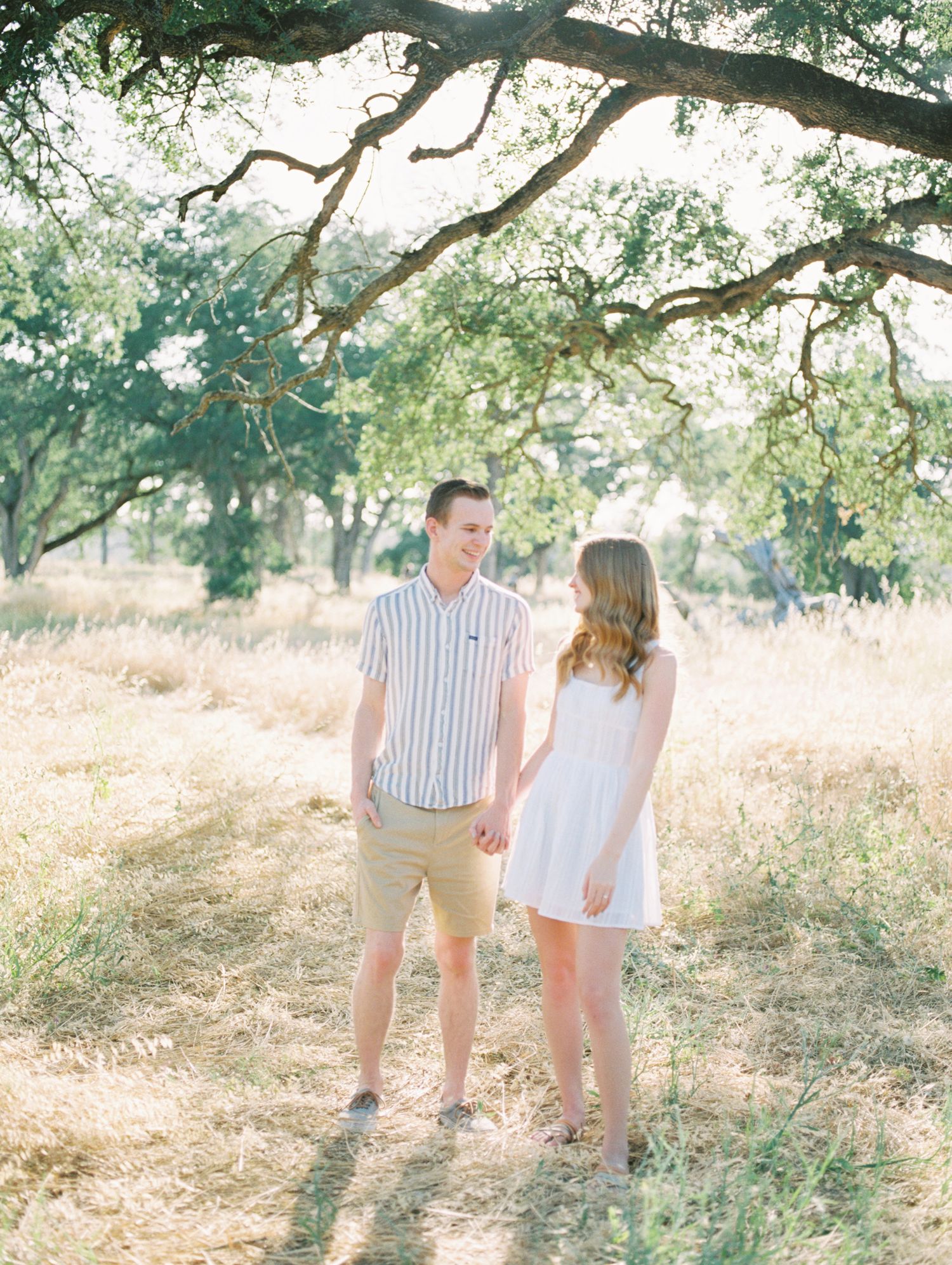 Film photo of couple embracing outdoors with sun flare in Boise, ID.