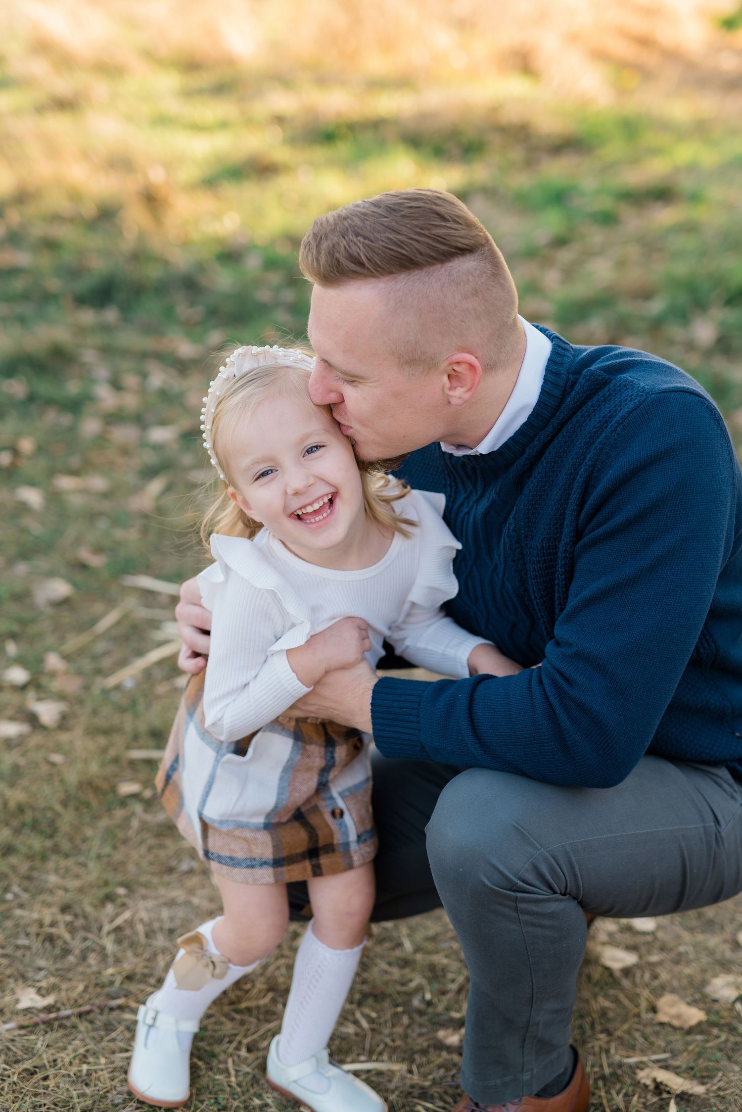 Dad holding toddler daughter during candid Boise family photography session.