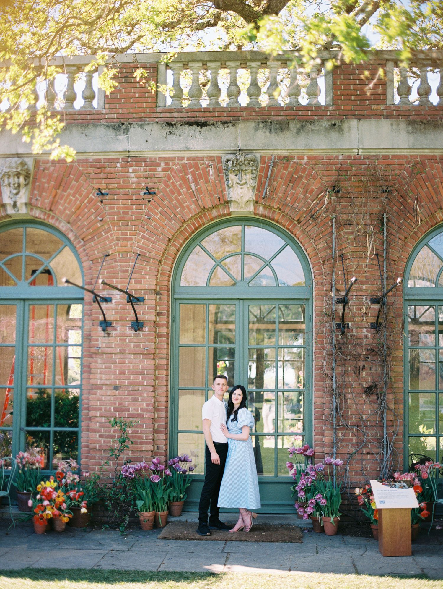 Film photo of couple embracing outdoors with sun flare in Filloli Gardens in the Bay Area