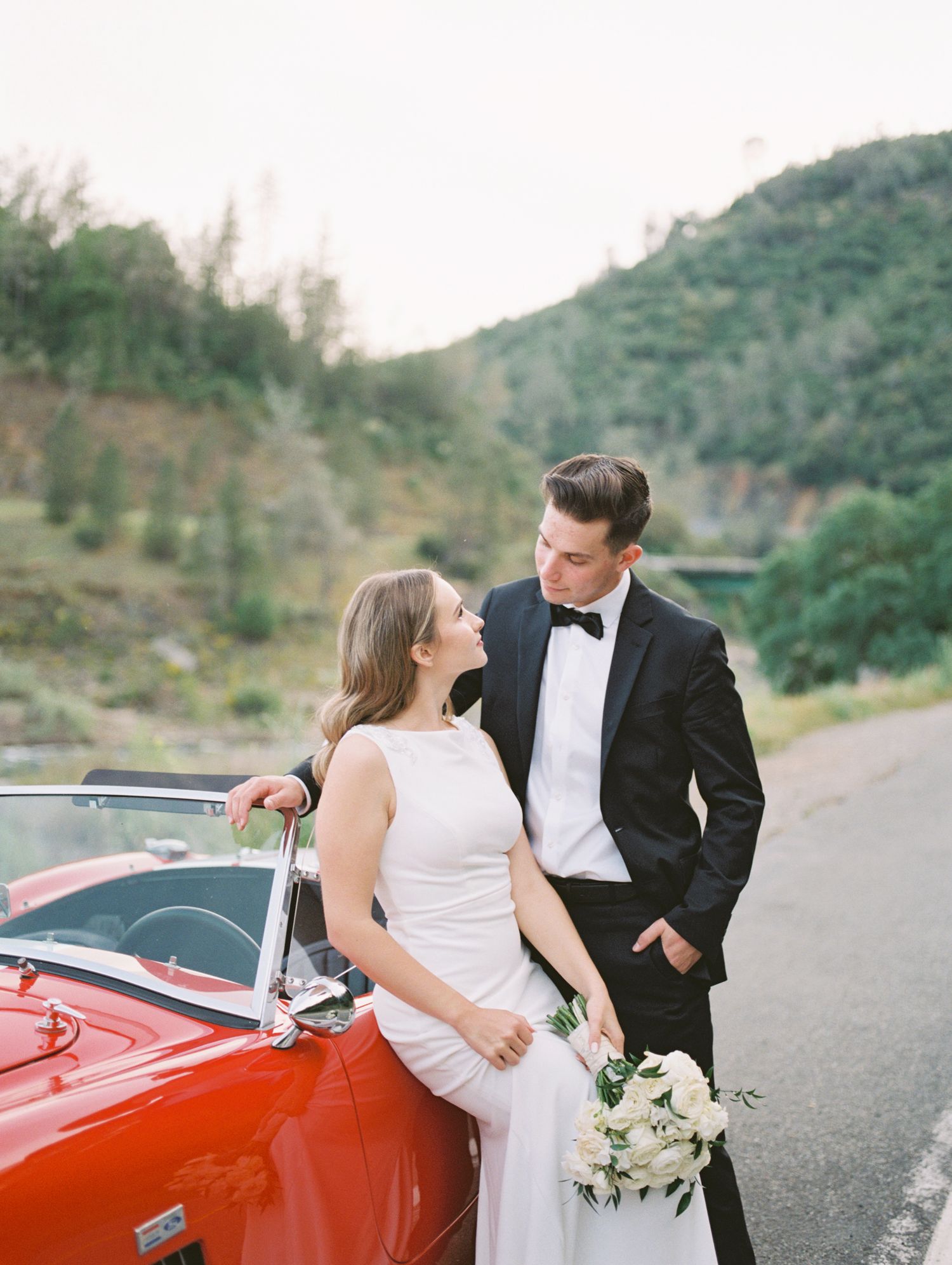 Couple laughing together during golden hour engagement session, 35mm film by Natalya Mark.
