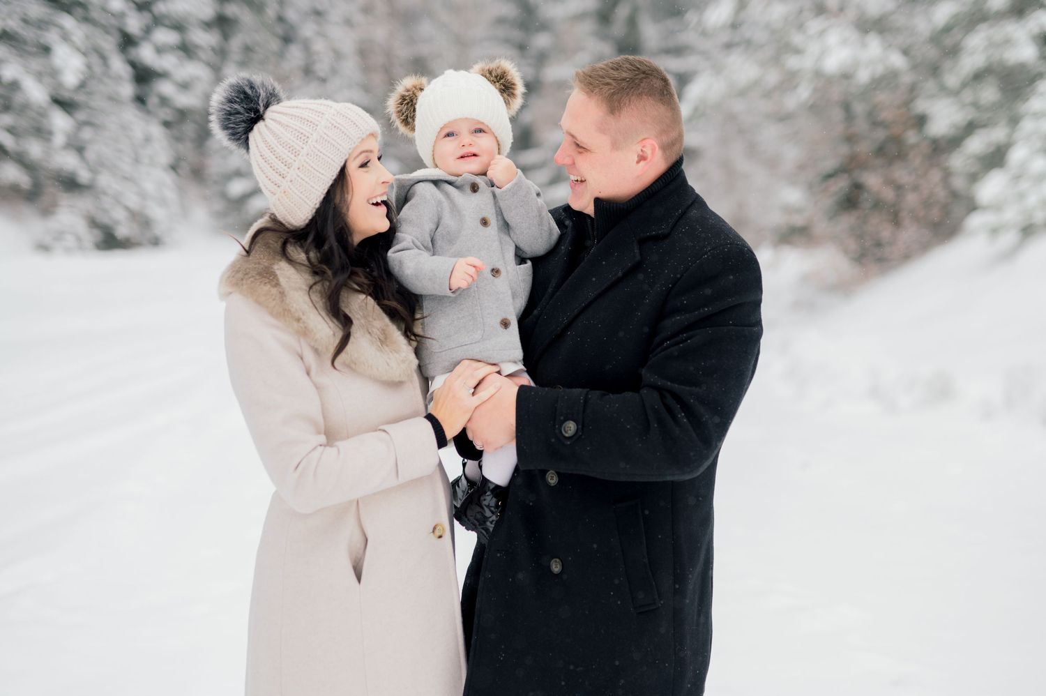 Family standing in snowy forest in the mountains during an Idaho maternity session.