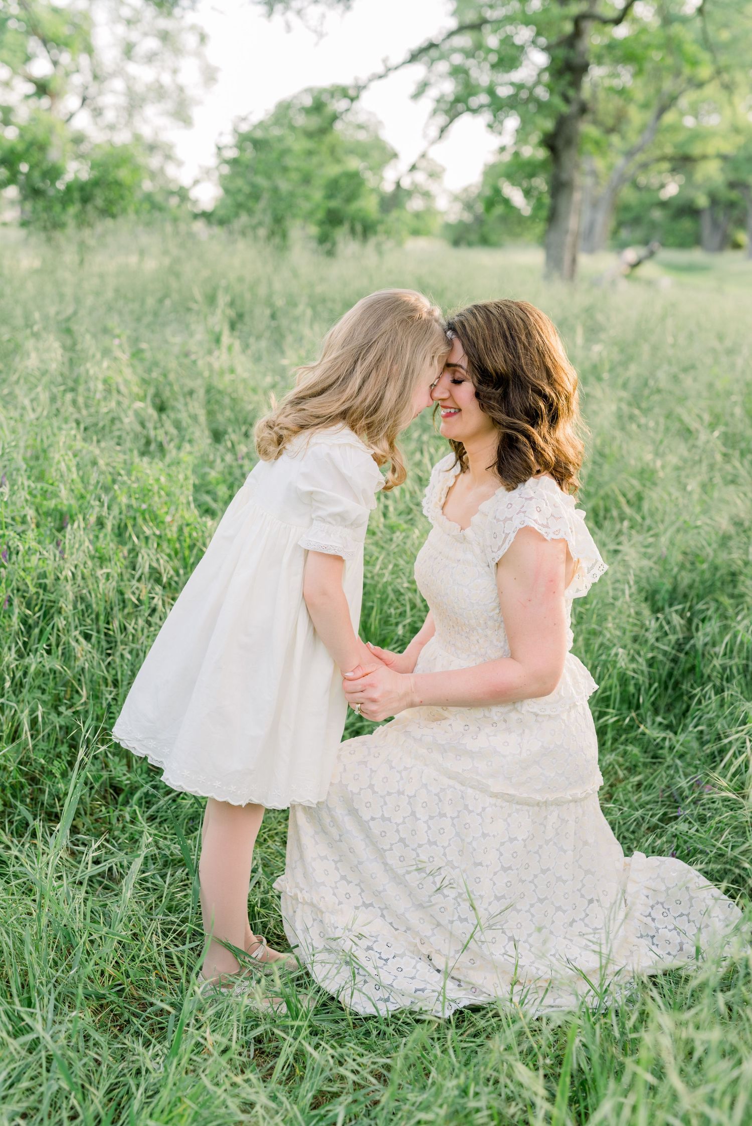 Candid moment of mom and her daughter sharing a snuggle in a field, taken by Boise family photographer Natalya Mark.