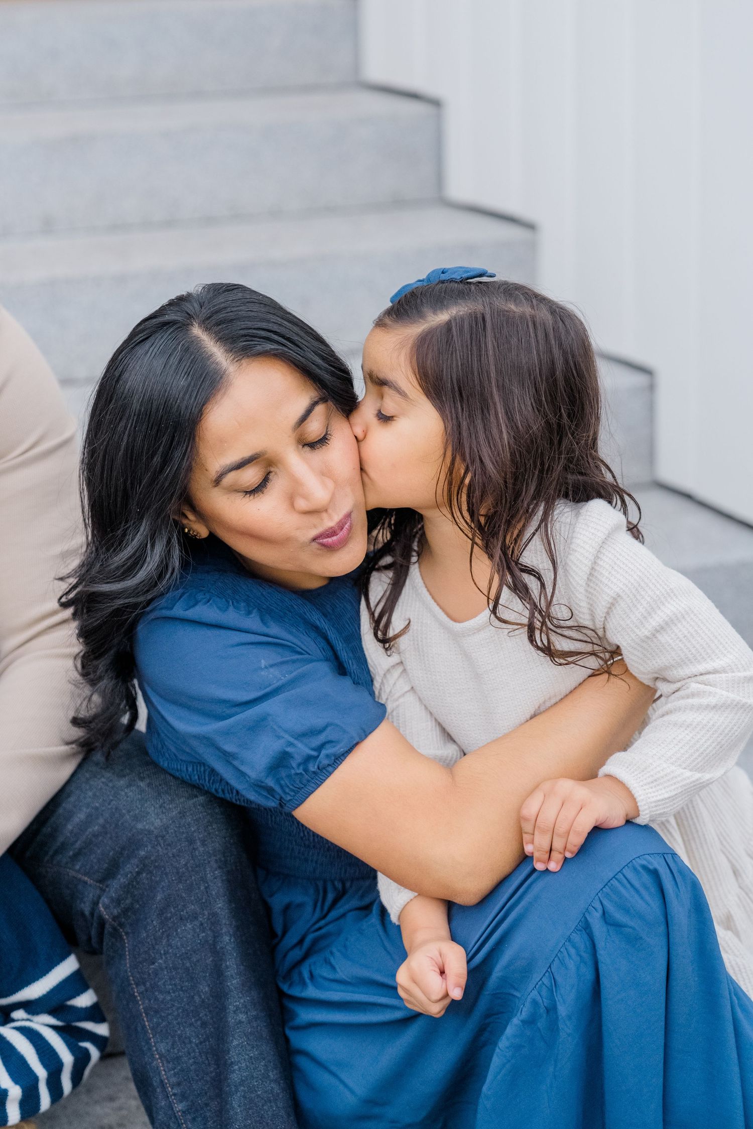 Mom and daughter hugging on the steps of a building in Meridian Idaho