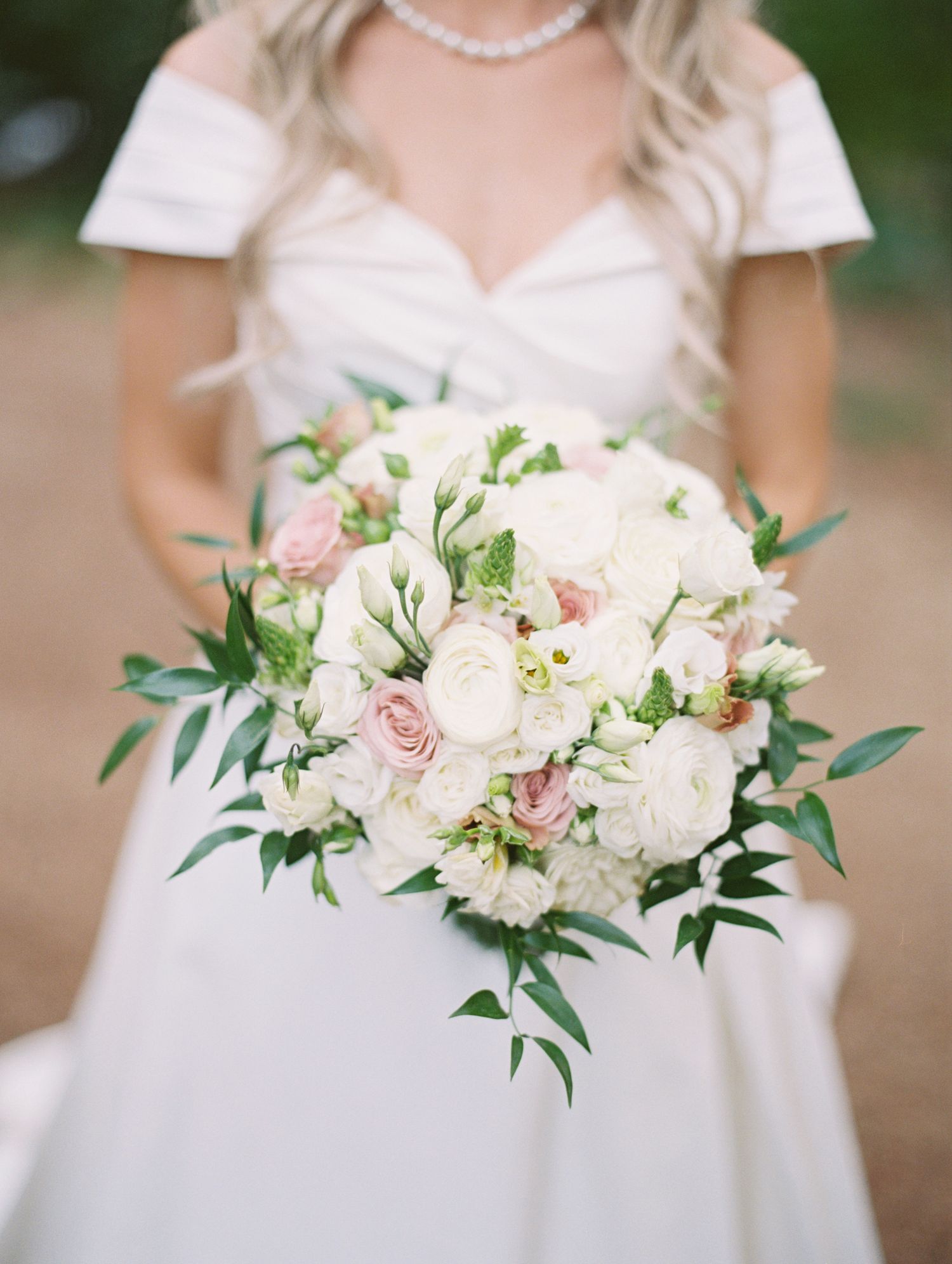 Soft bouquet of white roses and greenery  taken on film by Natalya Mark Photo.