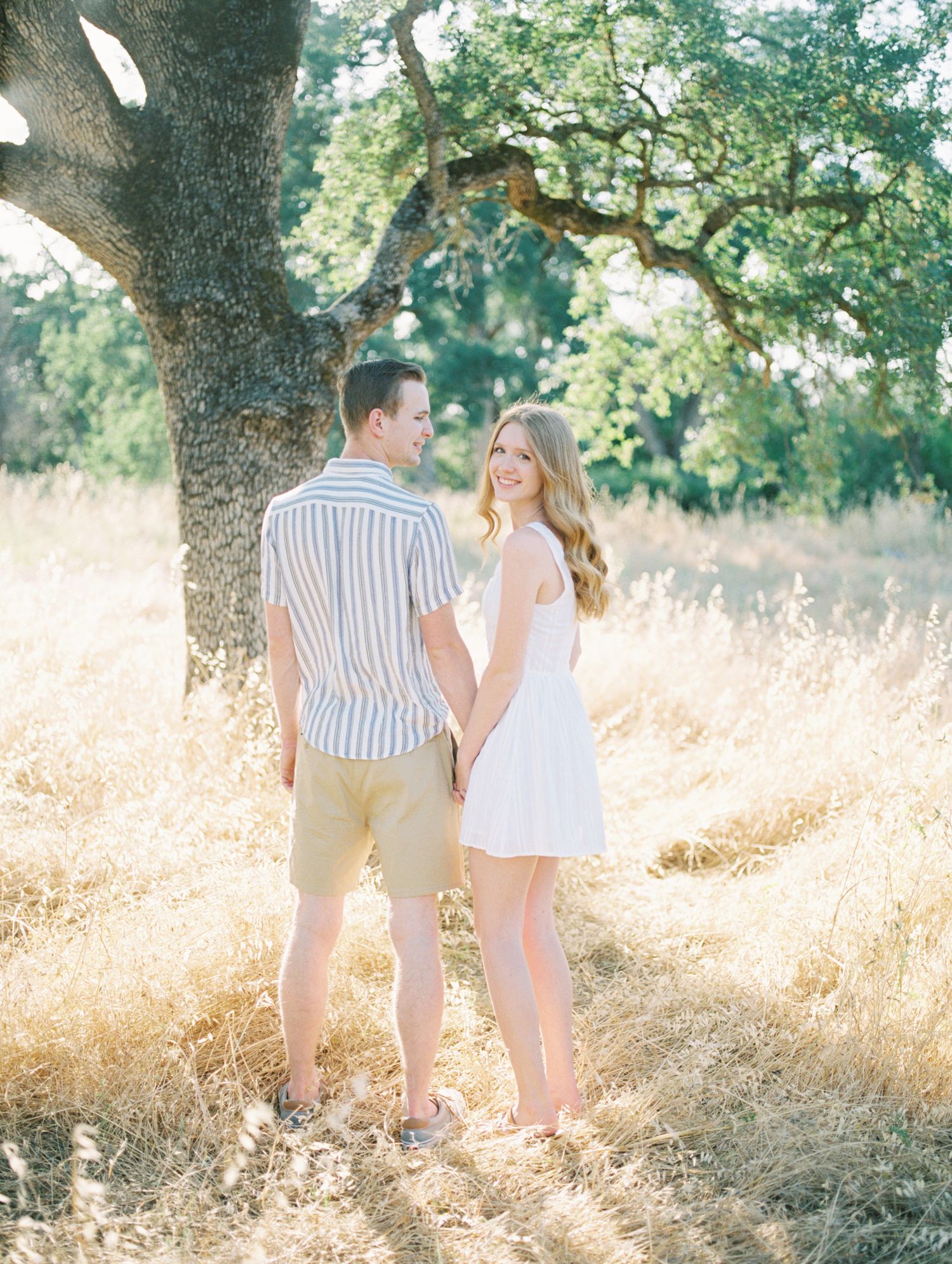 Film photo of couple embracing outdoors with sun flare in Boise, ID.