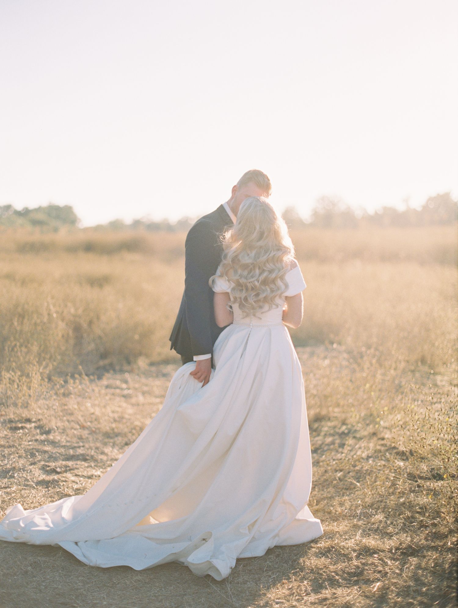 Couple laughing together during golden hour engagement session, 35mm film by Natalya Mark.
