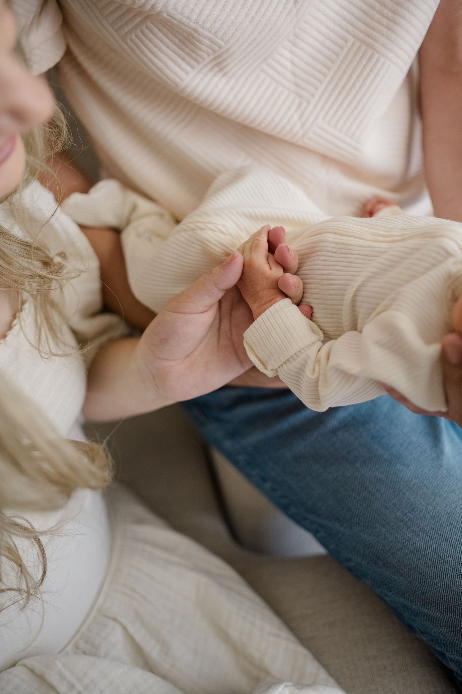 Mom and dad holding their newborn daughters hand during a newborn shoot in Meridian by Natalya Mark Photo