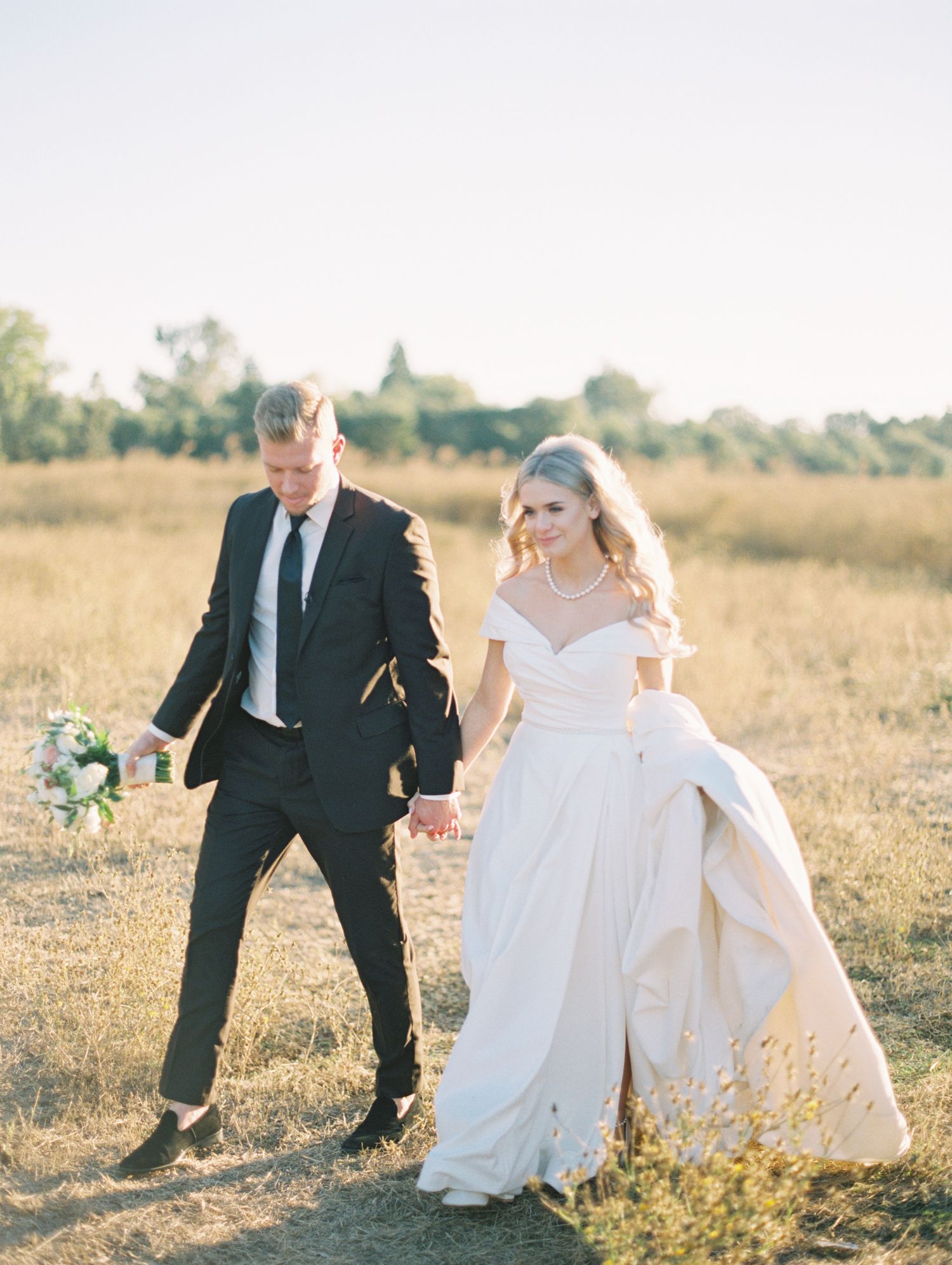 Couple laughing together during golden hour engagement session, 35mm film by Natalya Mark.