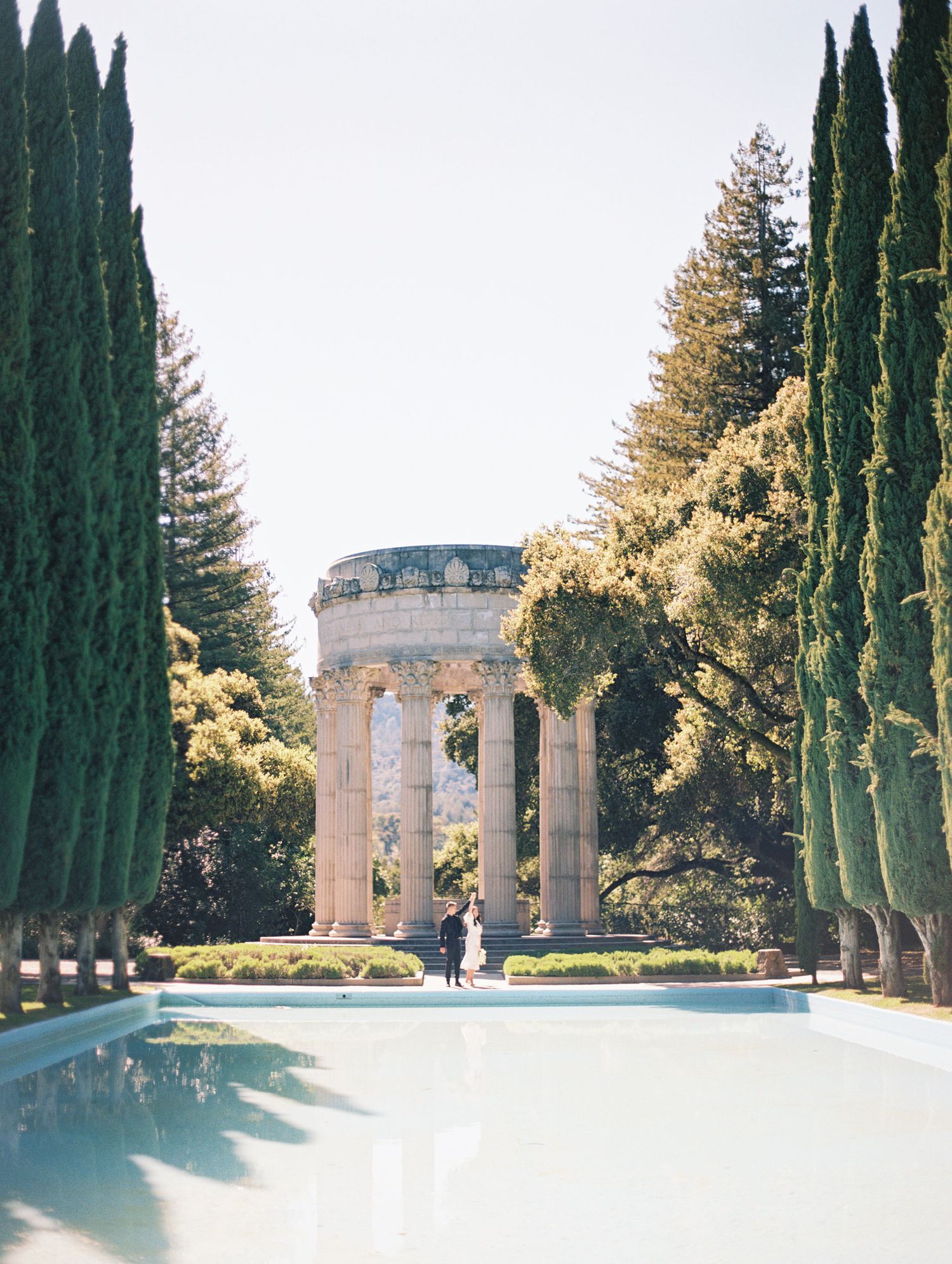 Film photo of couple embracing outdoors with sun flare near Filloli Gardens in the Bay Area