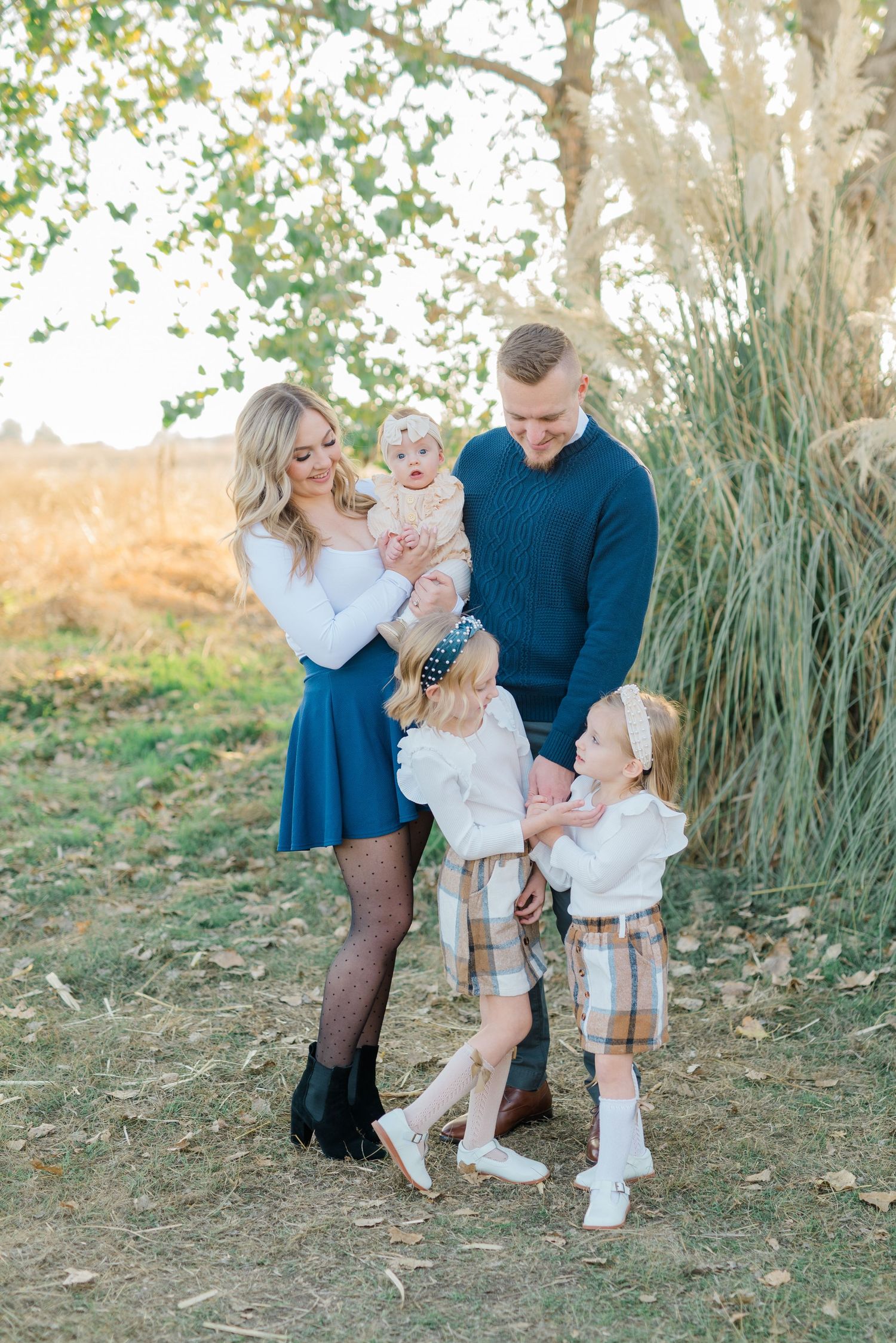 Family of four laughing during golden hour session in Meridian, Idaho, photographed by Natalya Mark Photo.