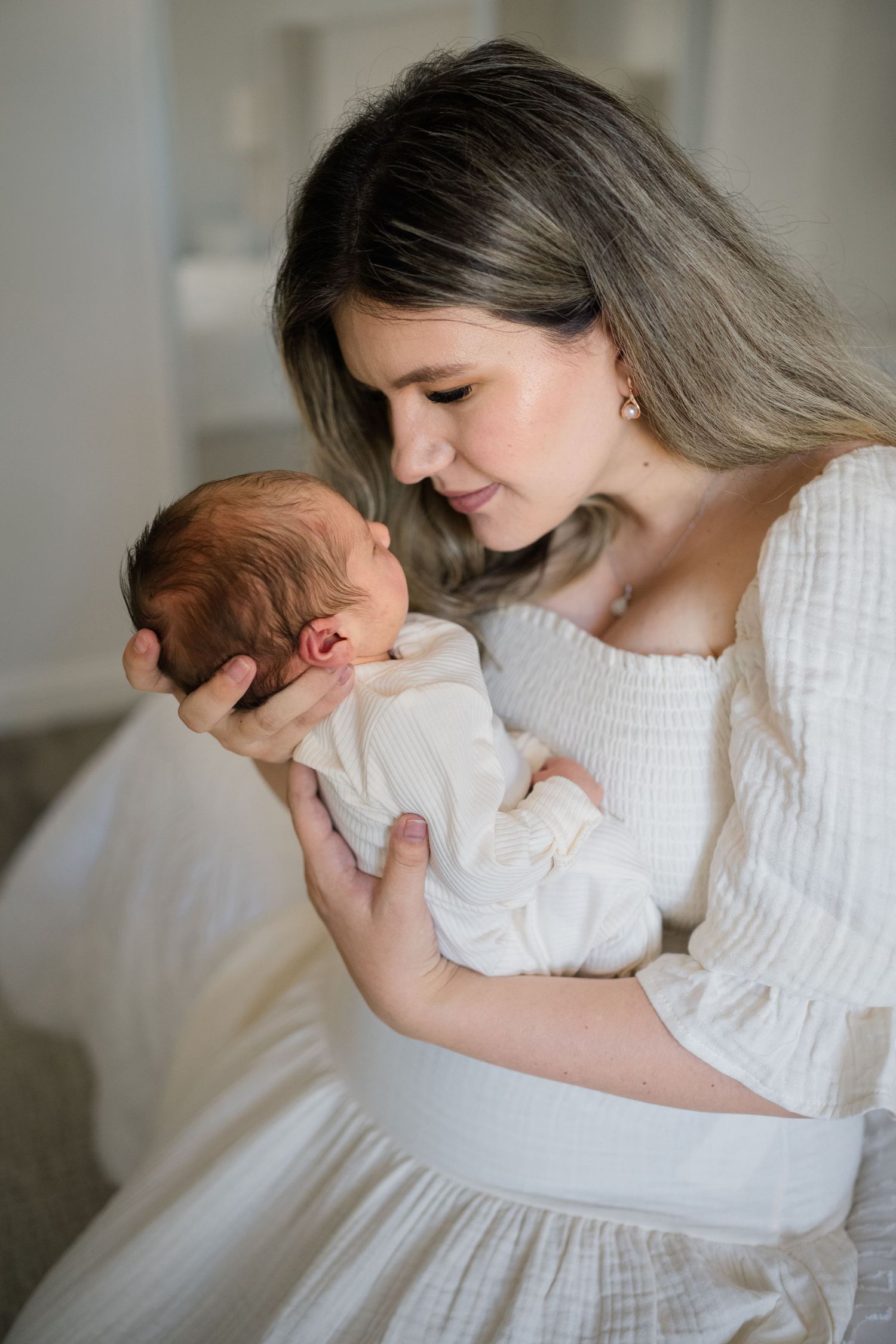 Mom snuggling her baby on a bed during her Newborn photoshoot shot by Natalya Mark Photo