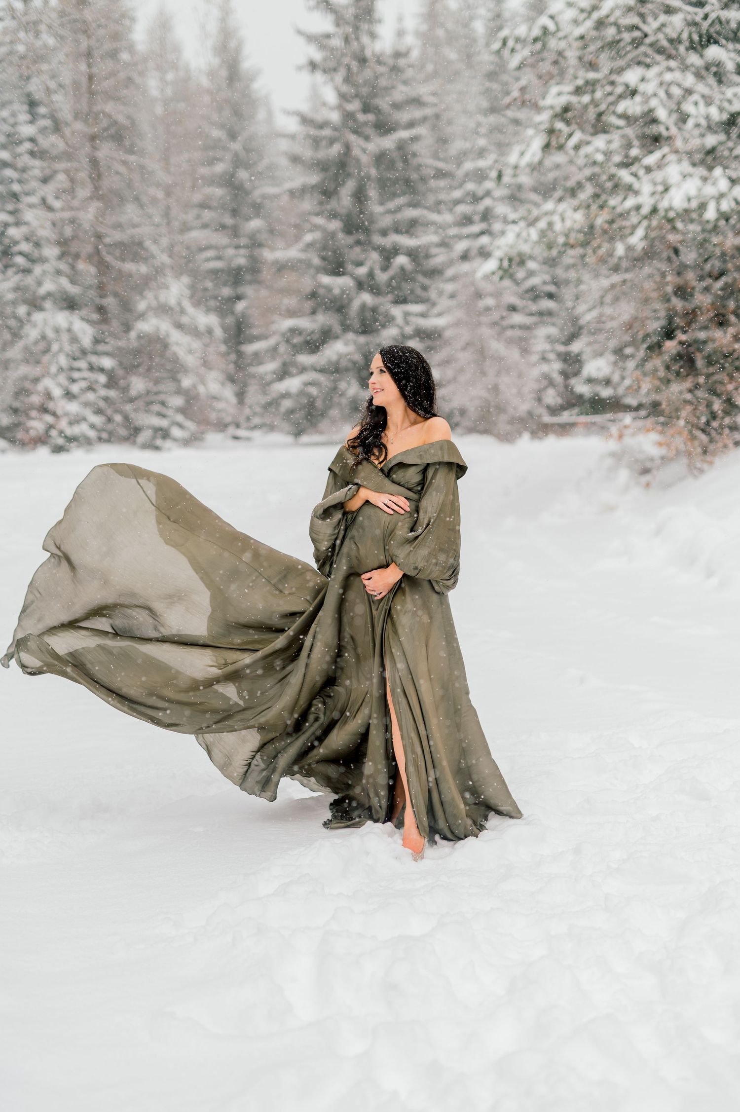 Pregnant mama standing in snowy forest in the mountains during an Idaho maternity session.