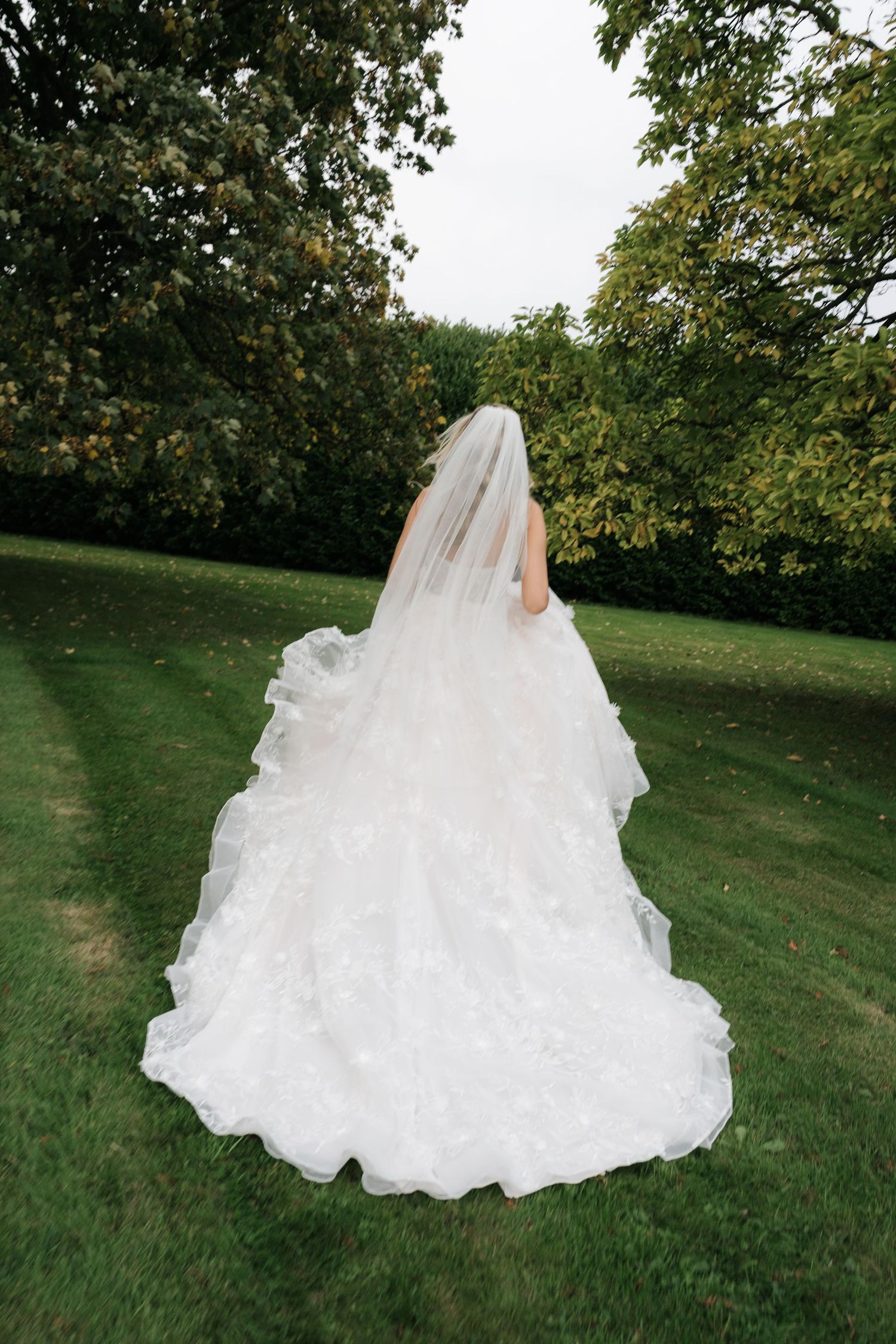 A flowing white wedding dress billows elegantly across a green lawn in a series of artistic outdoor photographs.
