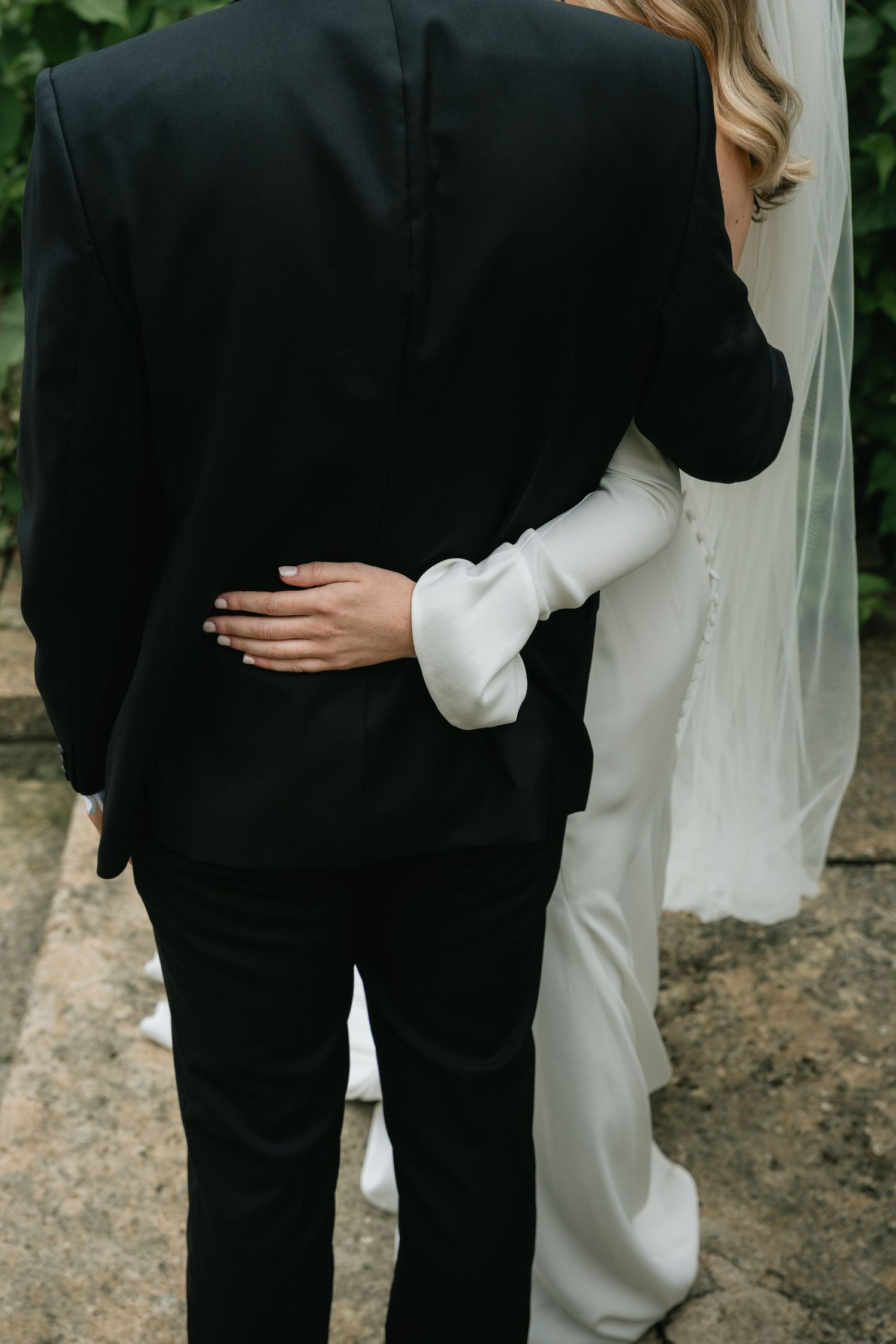 A series of intimate wedding photos showing a couple embracing in black and white formal attire.