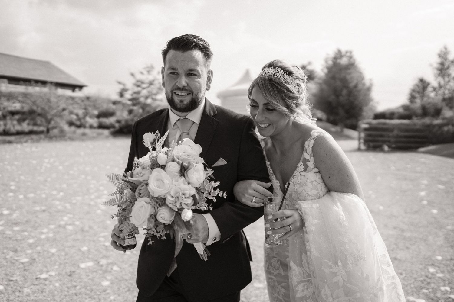 A couple shares a romantic moment on their wedding day in a rustic outdoor setting with natural lighting.