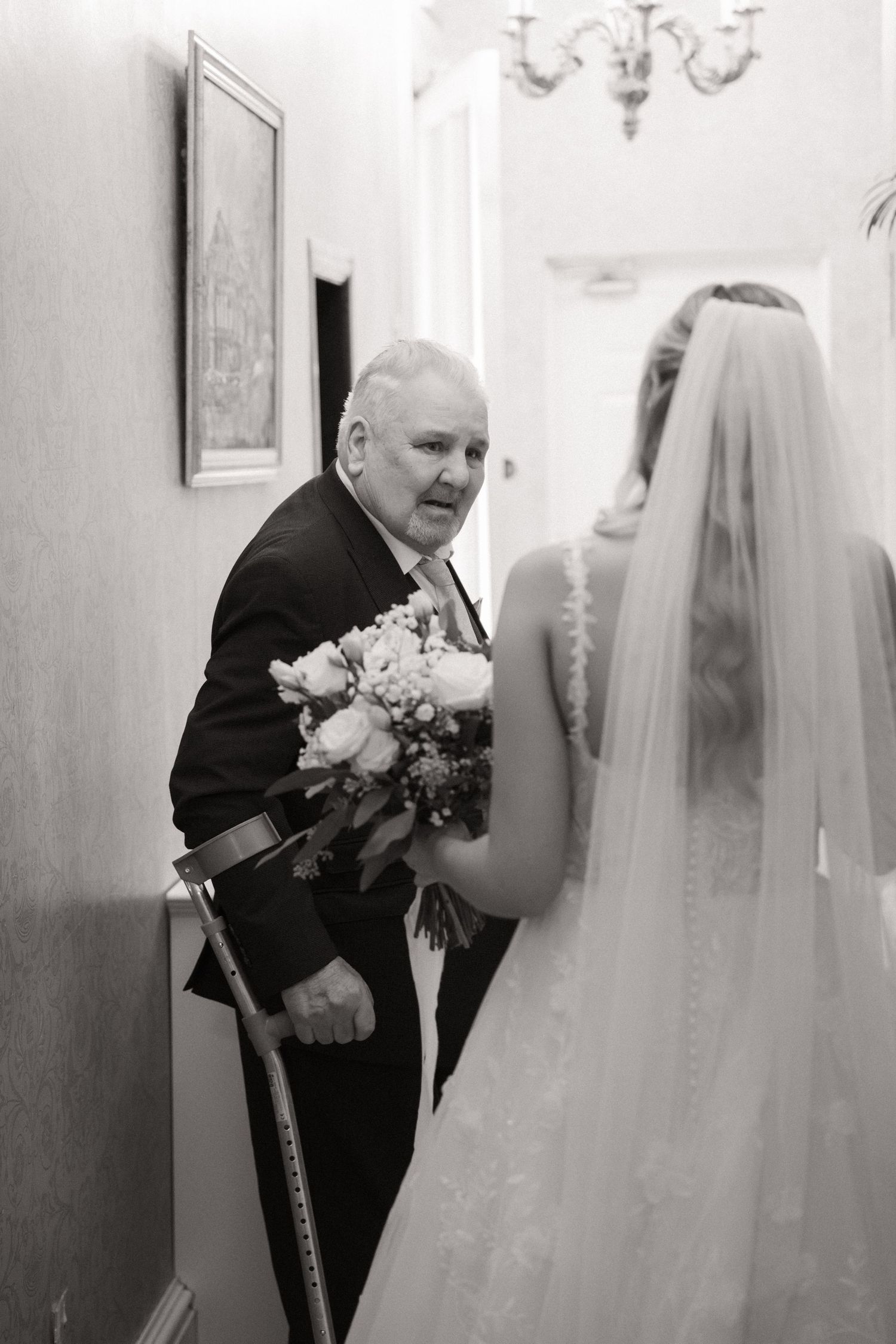 A series of black and white photos showing an emotional first look moment between a bride and her loved one at a wedding.