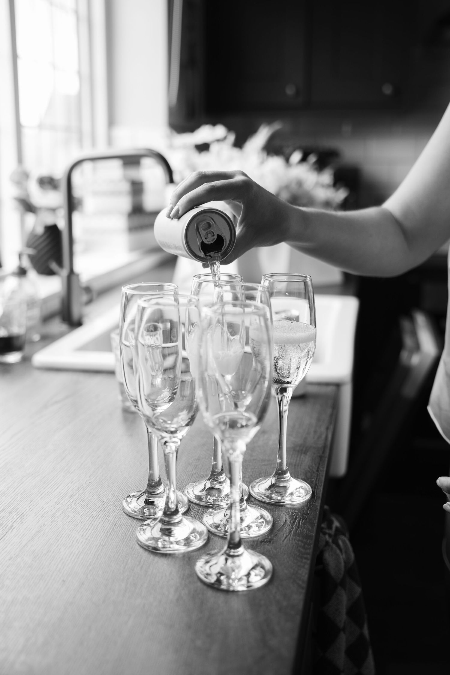 Empty wine glasses arranged on a wooden table in black and white photography.