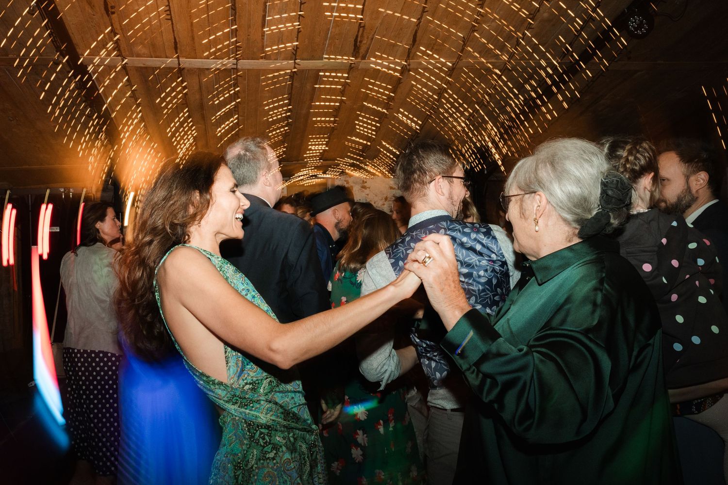 People dancing and celebrating together on a dance floor at a festive party or celebration event.