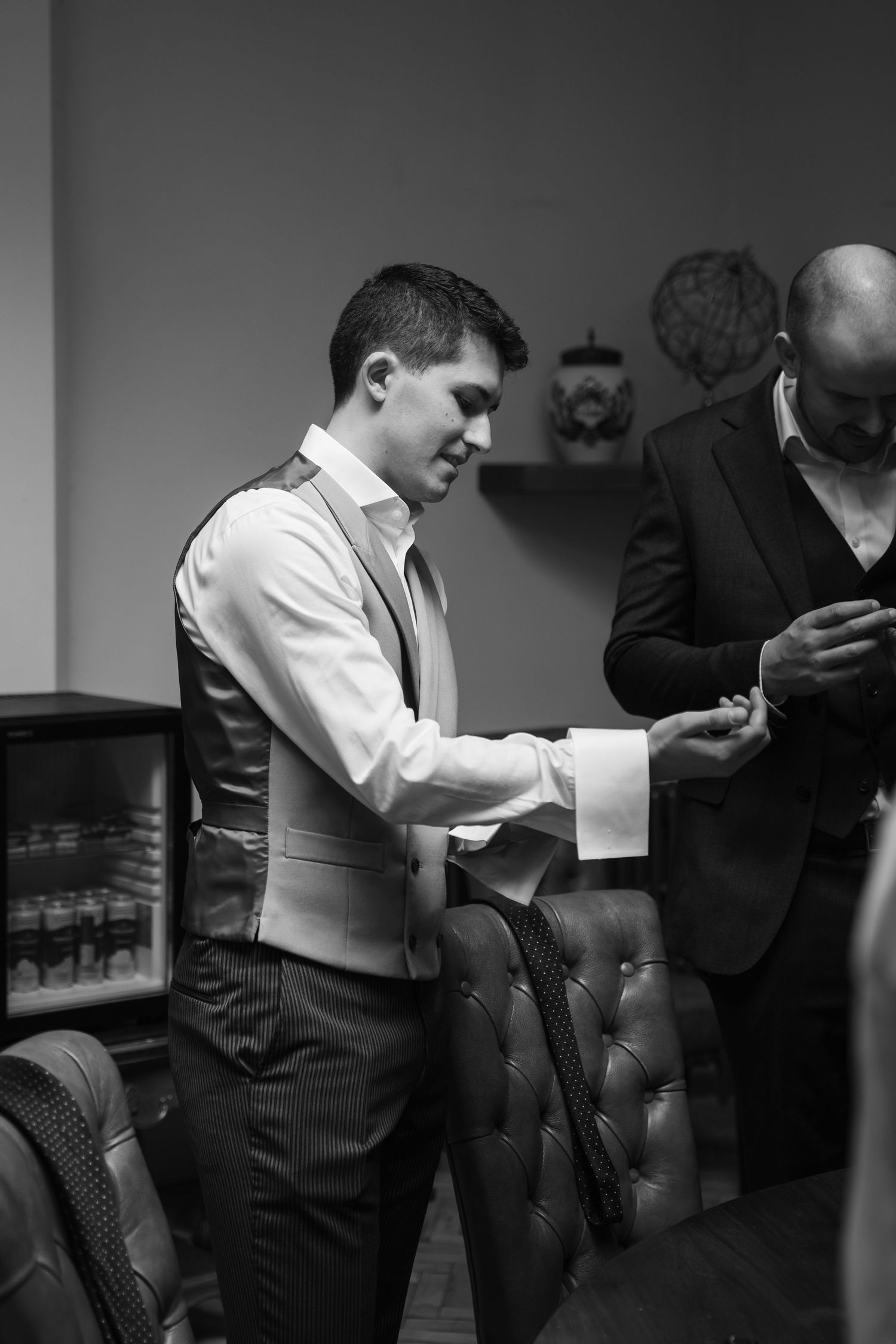 A sequence of black and white photos shows two people in formal attire engaged in conversation at a social gathering.