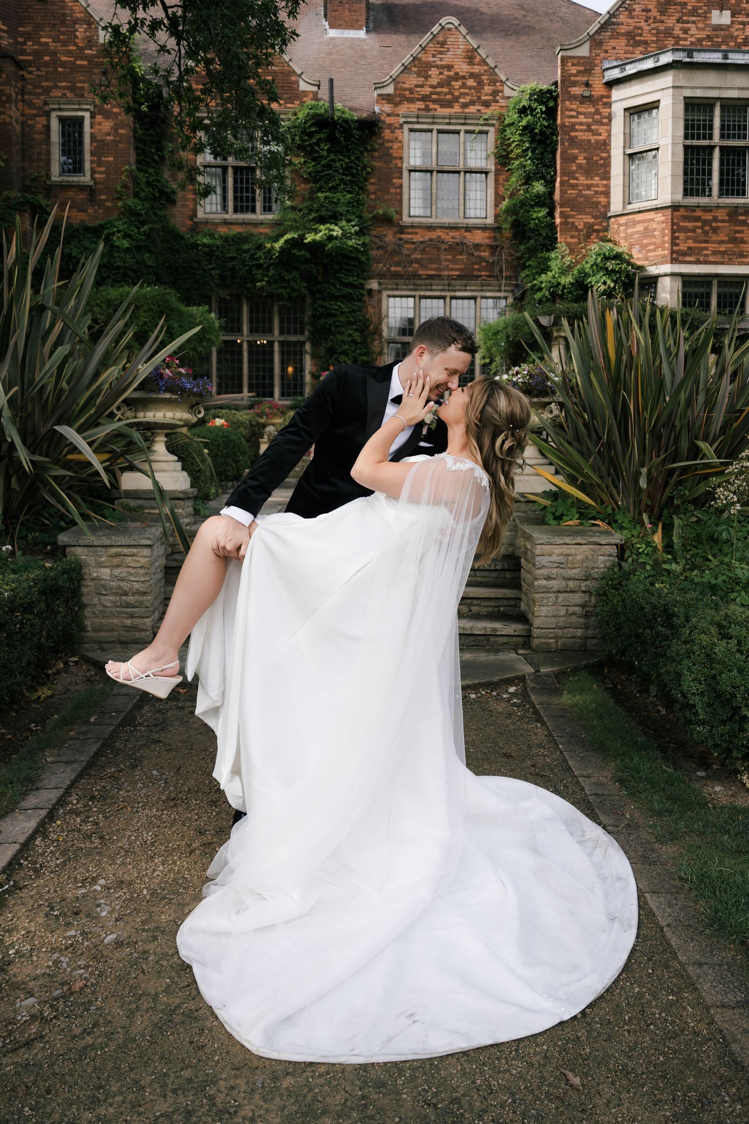 Sequence of playful wedding photos showing a couple swinging on an outdoor bench against a brick building backdrop.