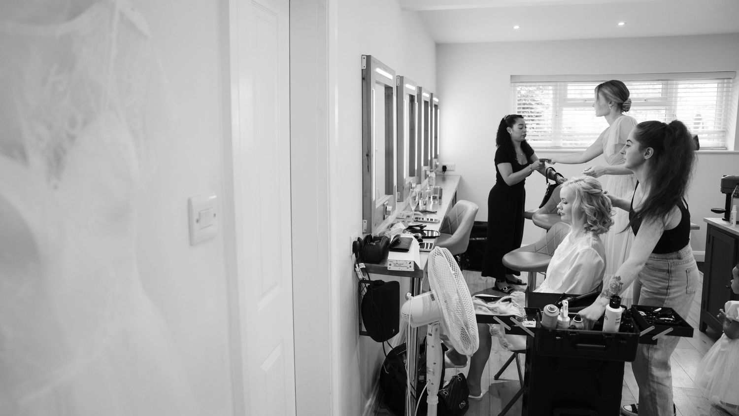Black and white panoramic photo showing people working in a modern office environment with desks and computers.