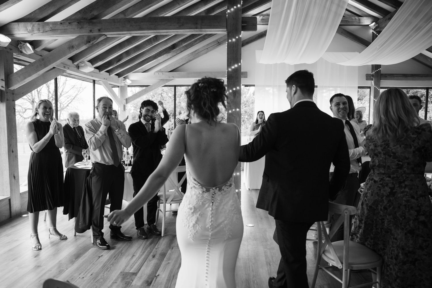 Wedding reception venue with exposed beams and elegant white draping.