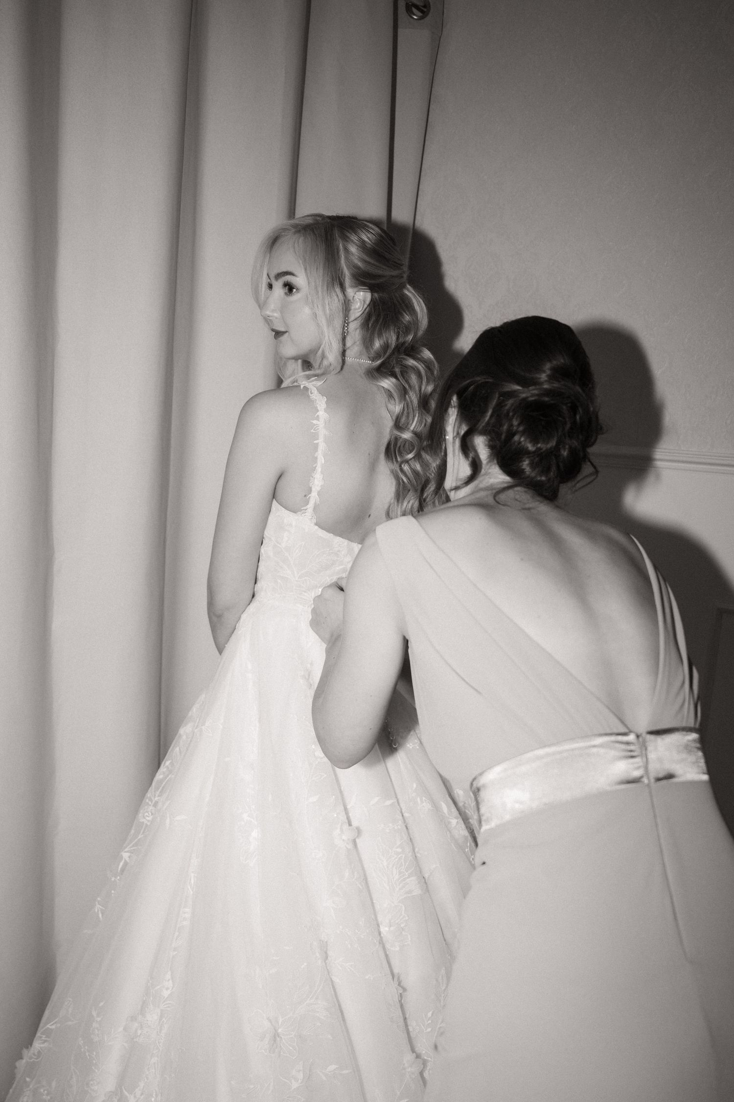 Black and white photo series showing a person in a white dress peeking through window blinds.