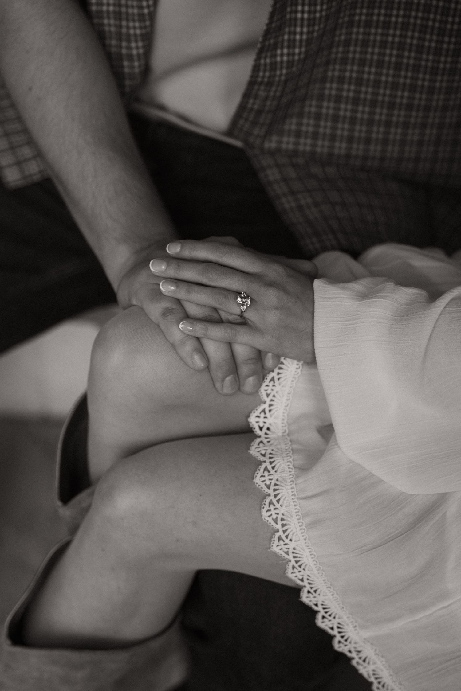 A sequence of black and white photos showing hands gently touching delicate lace fabric details.
