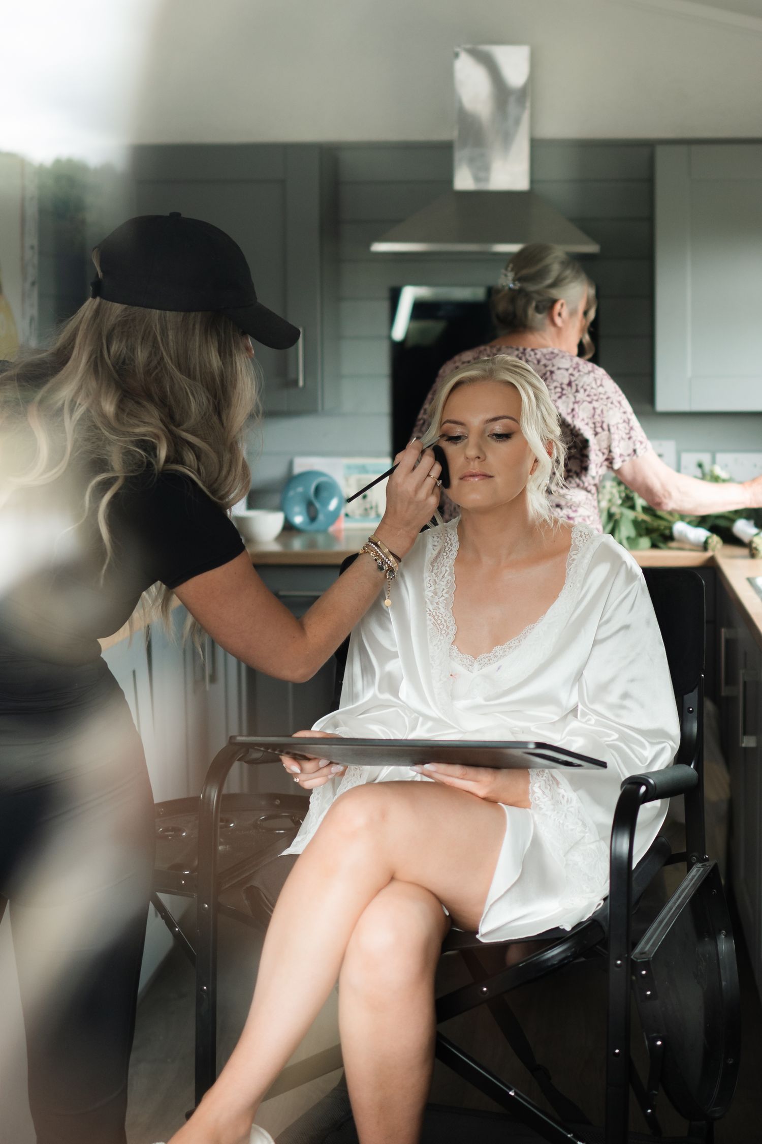 A bridal preparation scene showing someone getting their hair and makeup done in a modern salon setting.