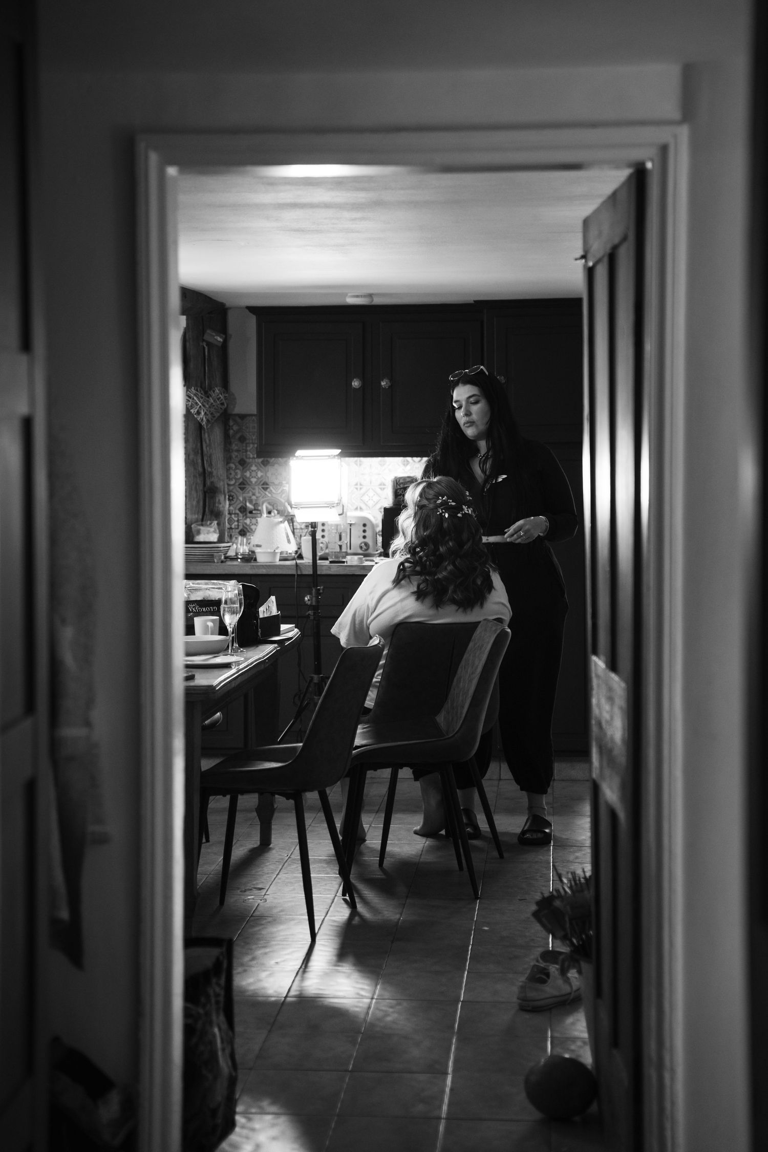 A dramatic black and white film noir style sequence showing figures in a dimly lit hallway and room interior.