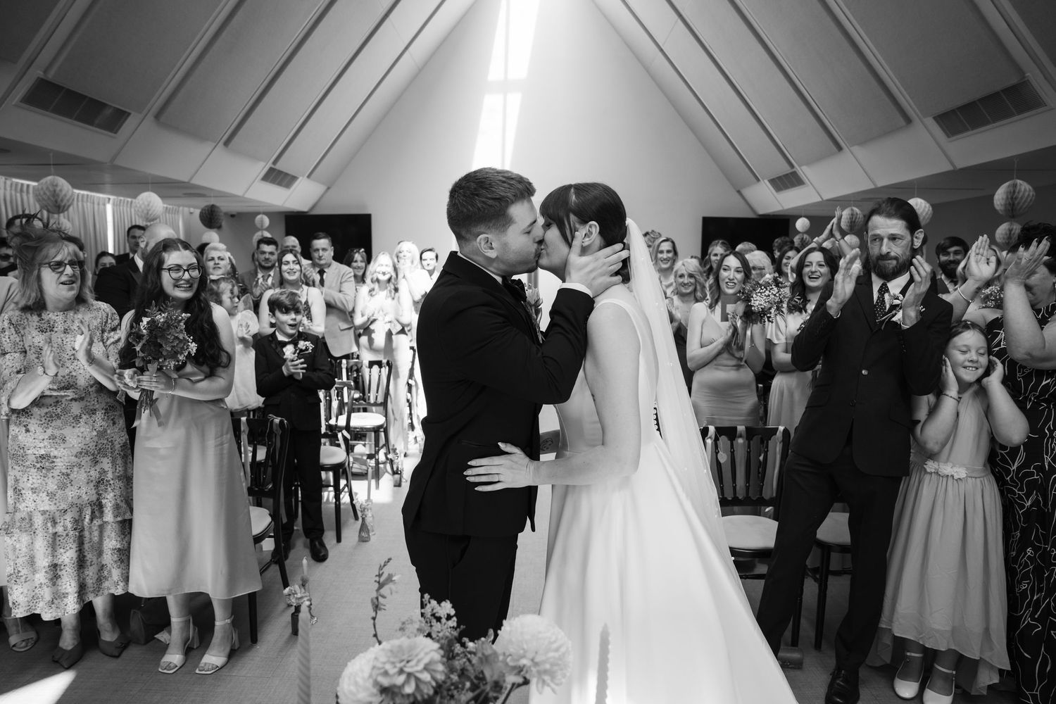 Wedding guests gather in a circle on the dance floor during a reception celebration.