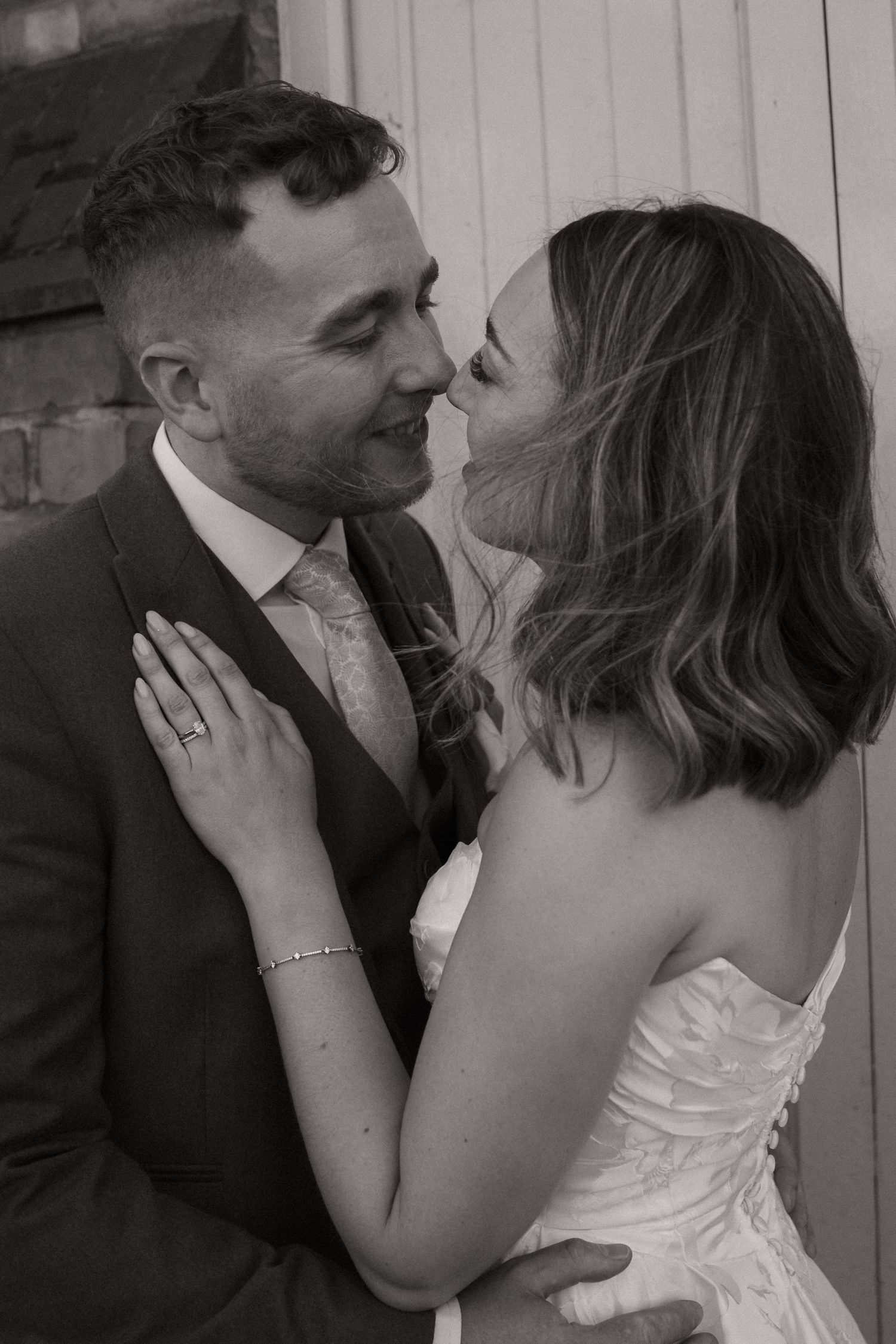 A romantic black and white photo sequence shows a couple in wedding attire sharing tender moments together.