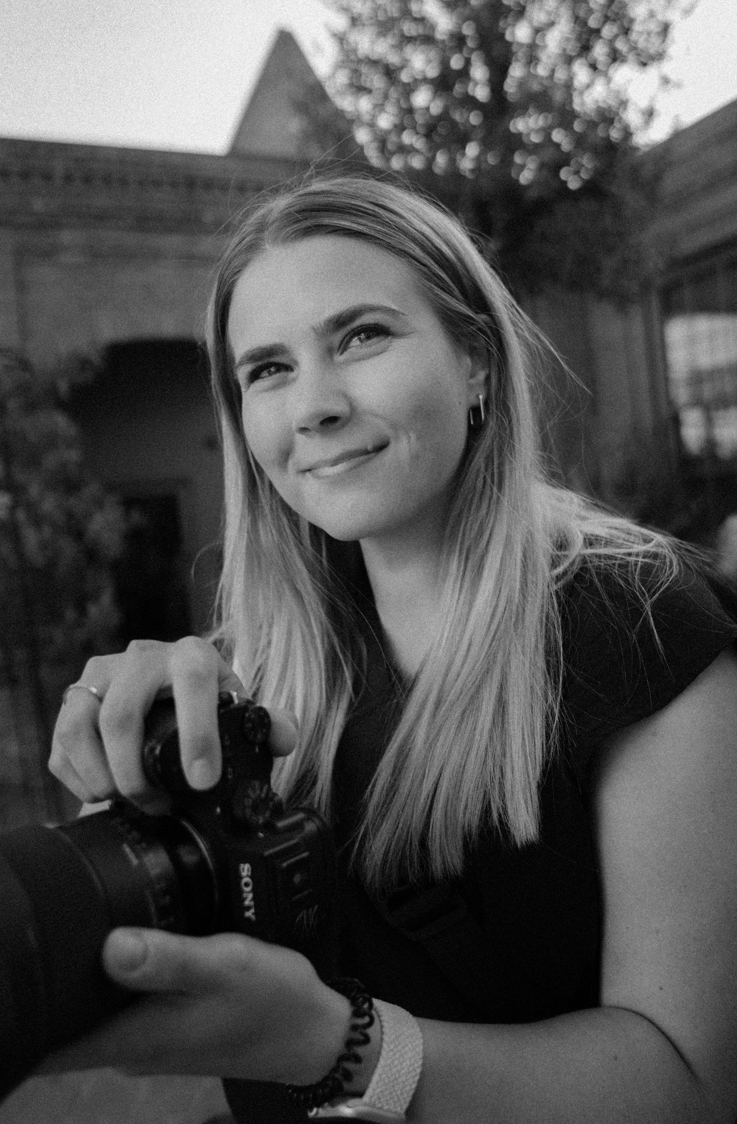Black and white portraits of photographer reviewing images on camera.